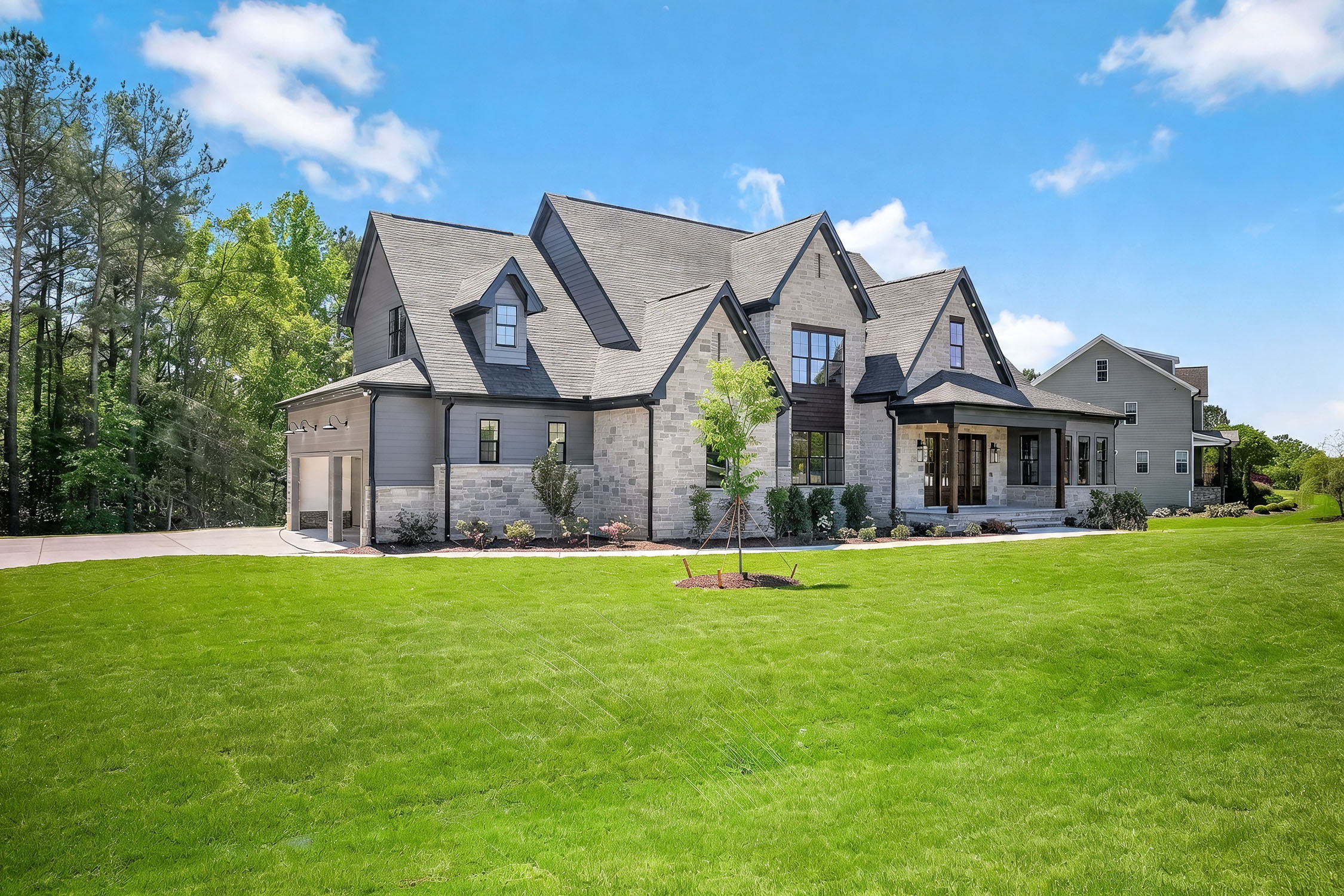 Modern stone house with large manicured lawn