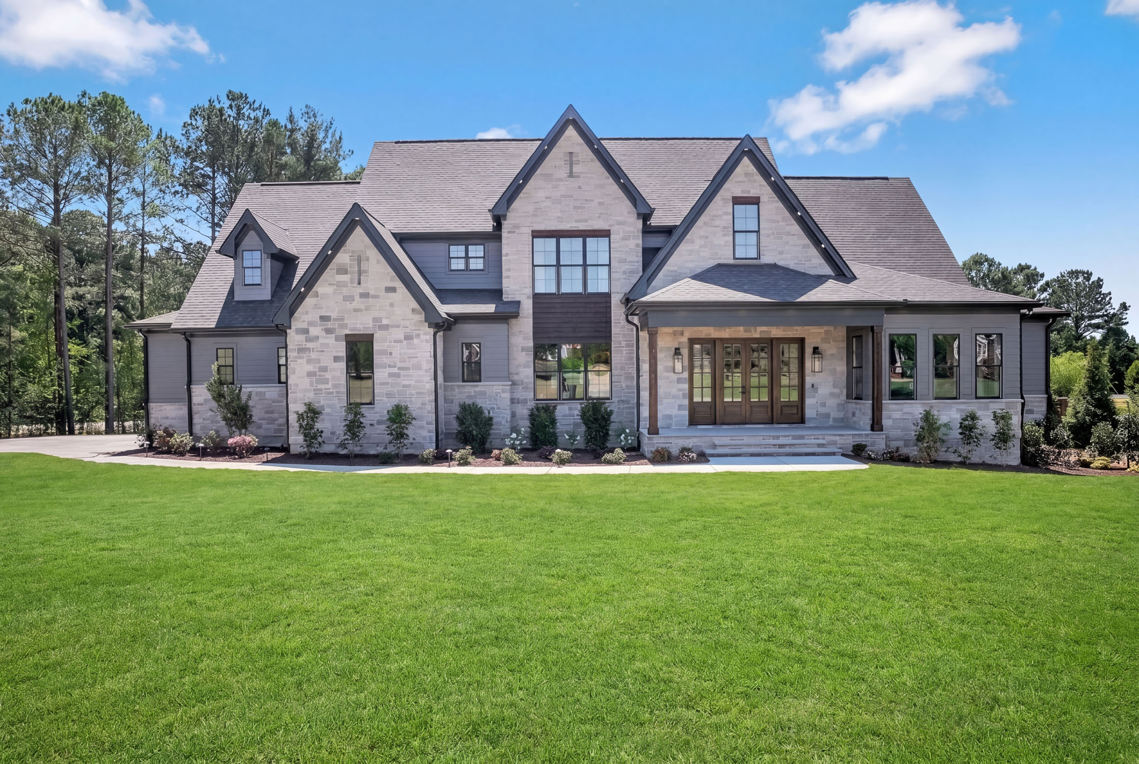 Large modern stone house with manicured lawn