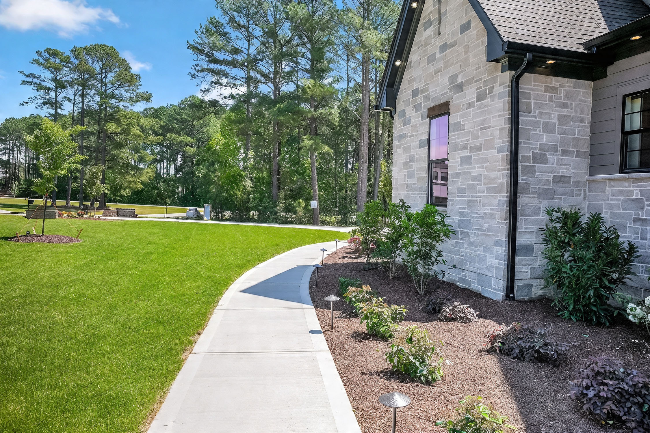 Modern stone house with landscaped yard and walkway