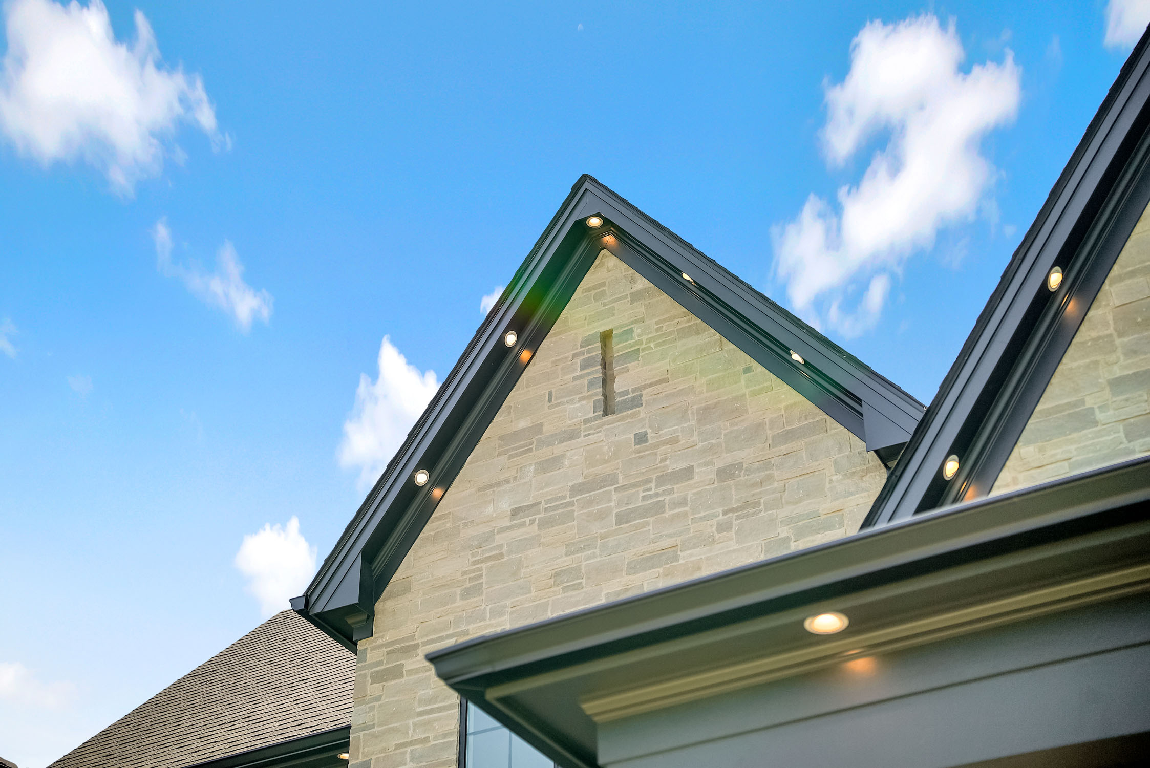 Modern stone house gable against blue sky