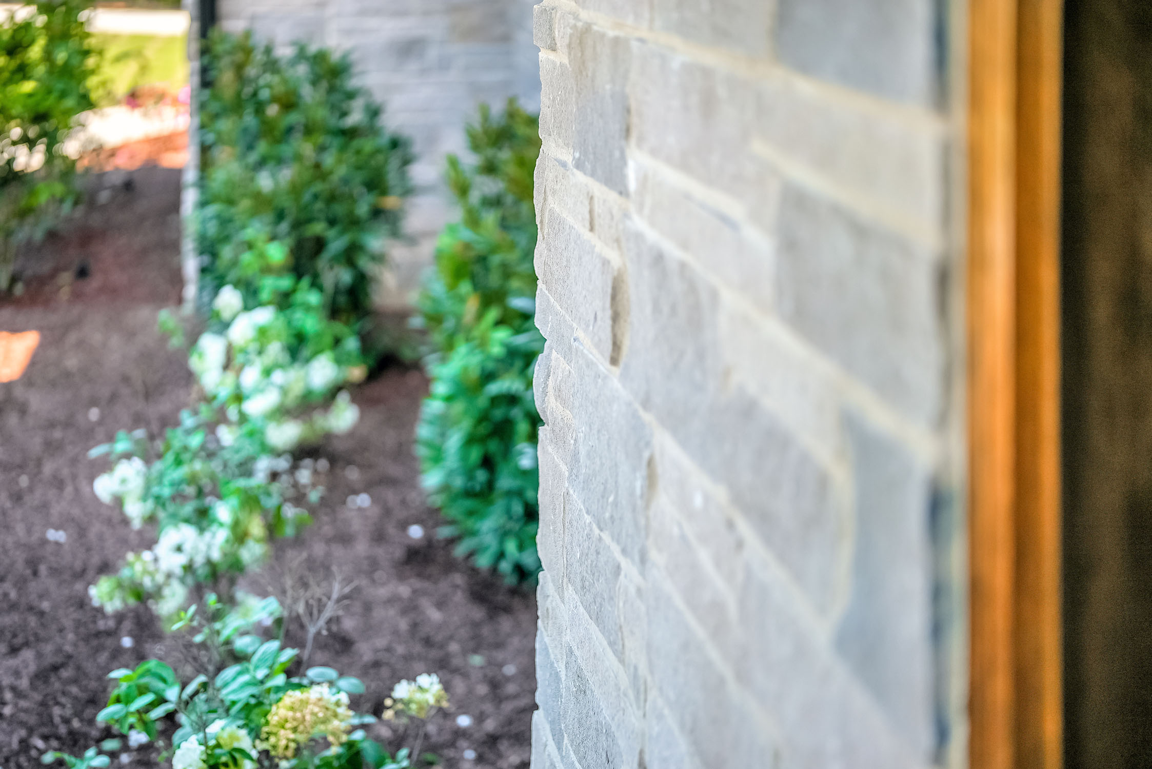 Stone house exterior with garden bed and flowers