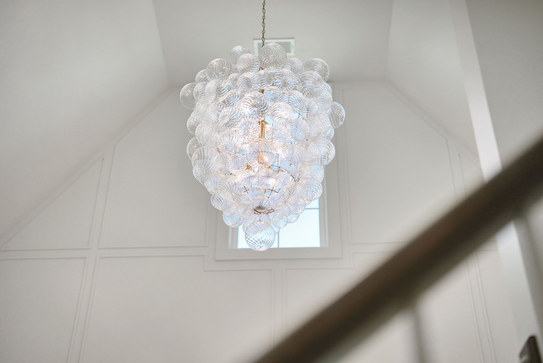 Modern glass orb chandelier in bright foyer