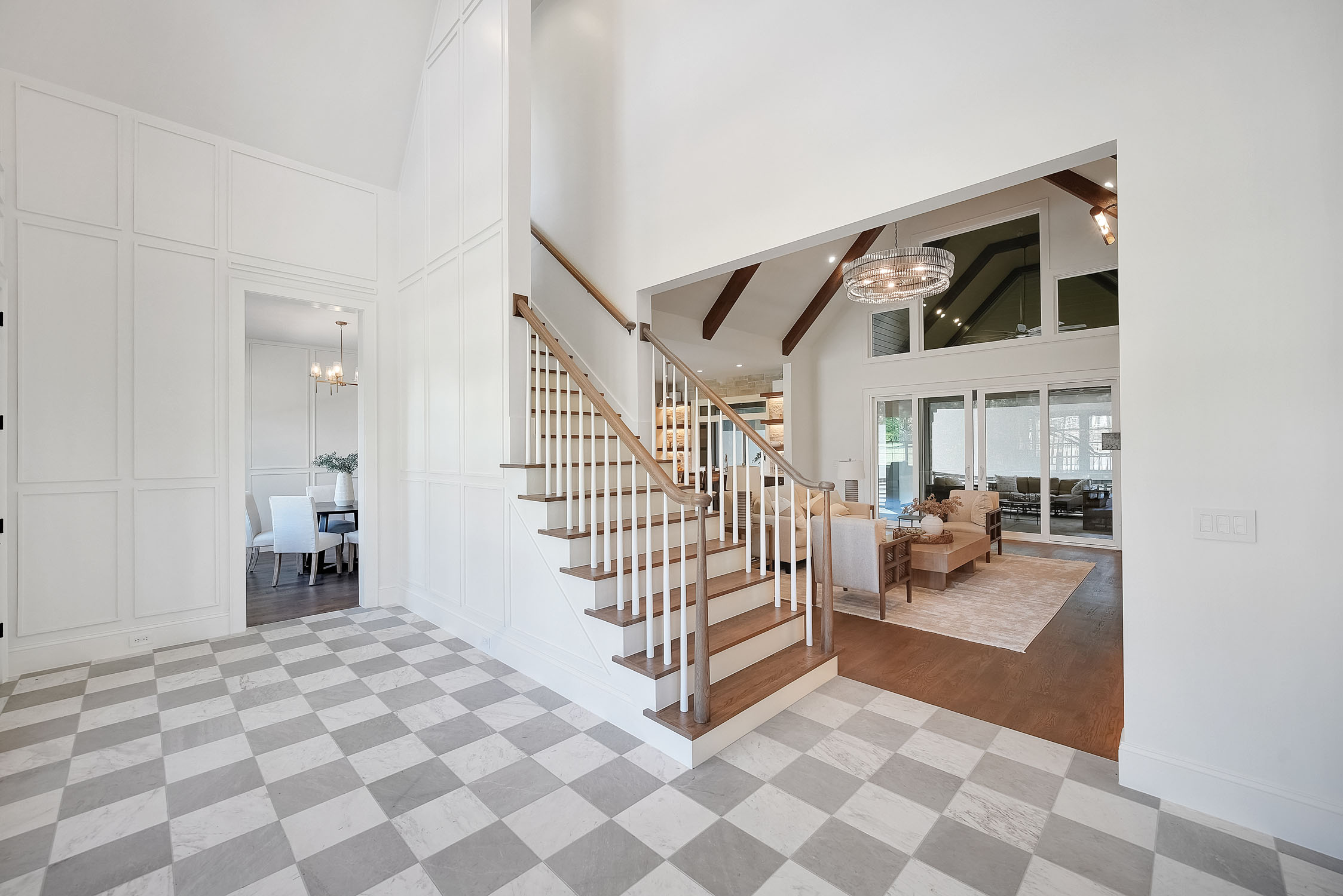 Bright modern foyer with staircase and open living room