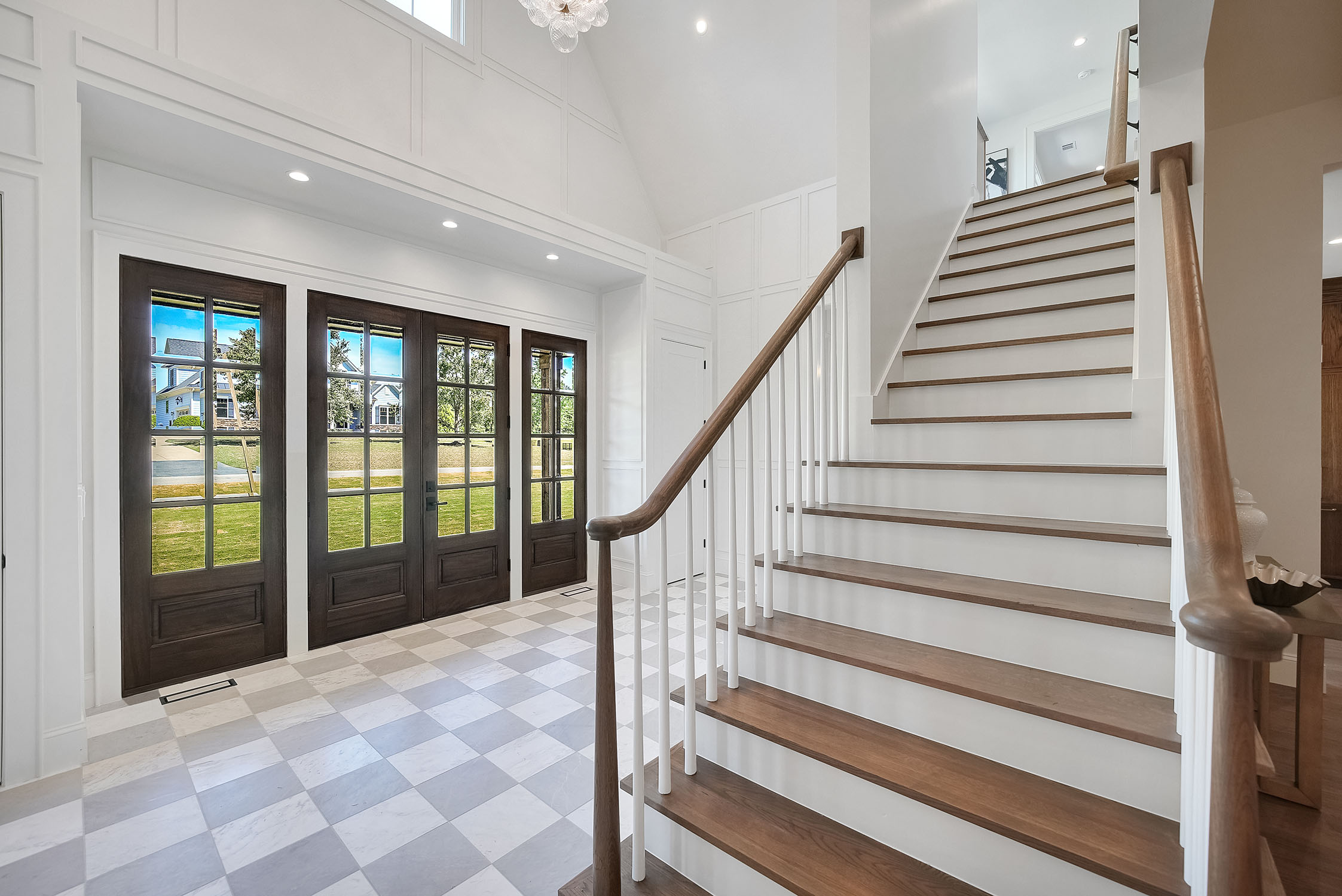 Bright modern foyer with staircase and glass doors