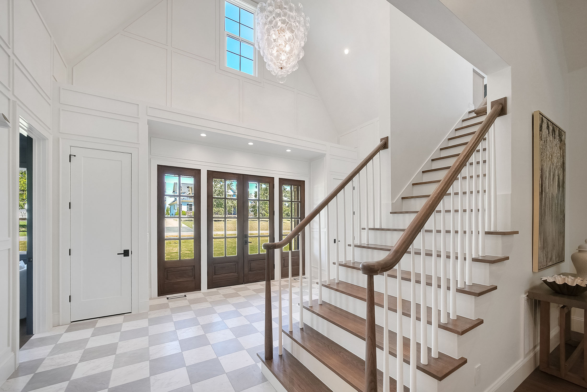 Bright modern foyer with staircase and chandelier