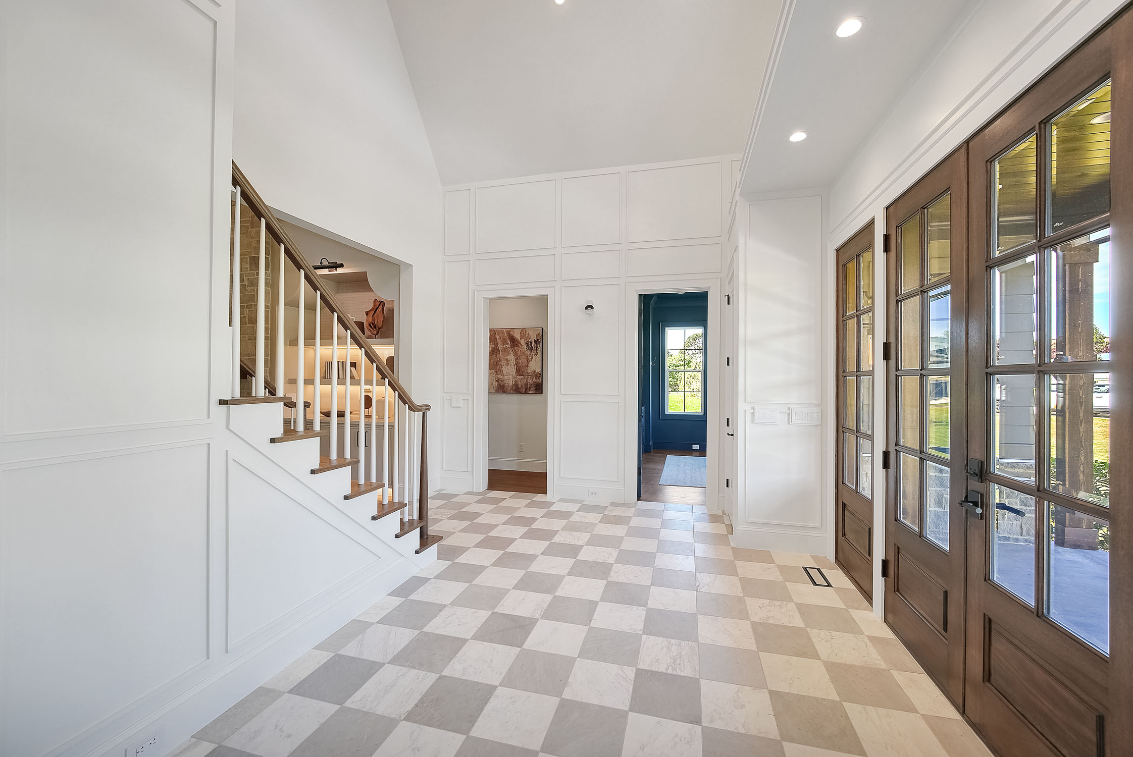 Bright modern foyer with staircase and checkered floor