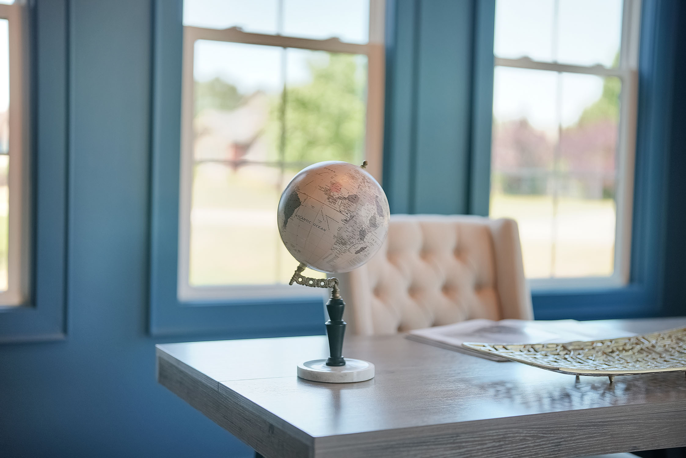 Decorative globe on desk by sunlit windows