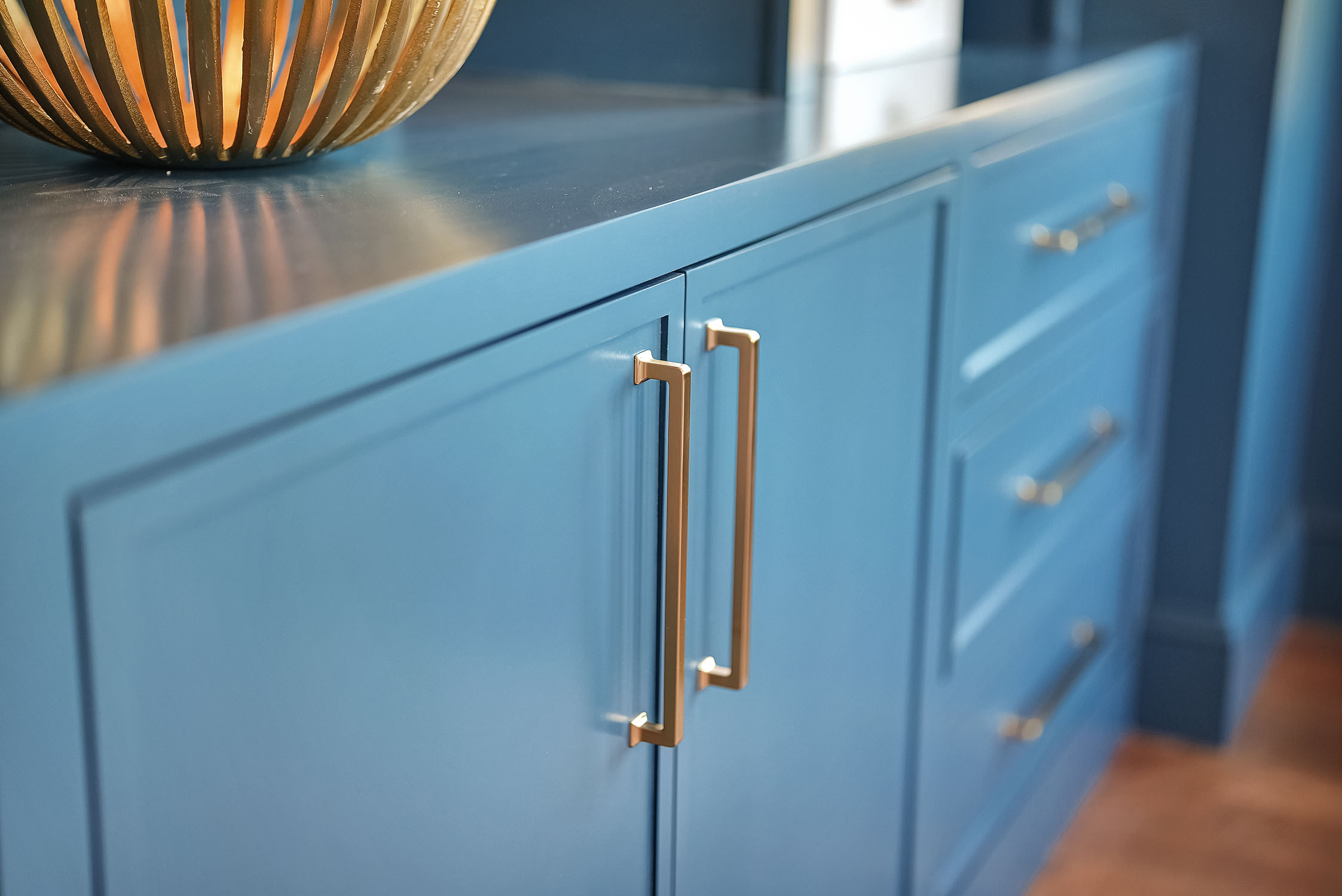 Blue kitchen cabinets with gold handles