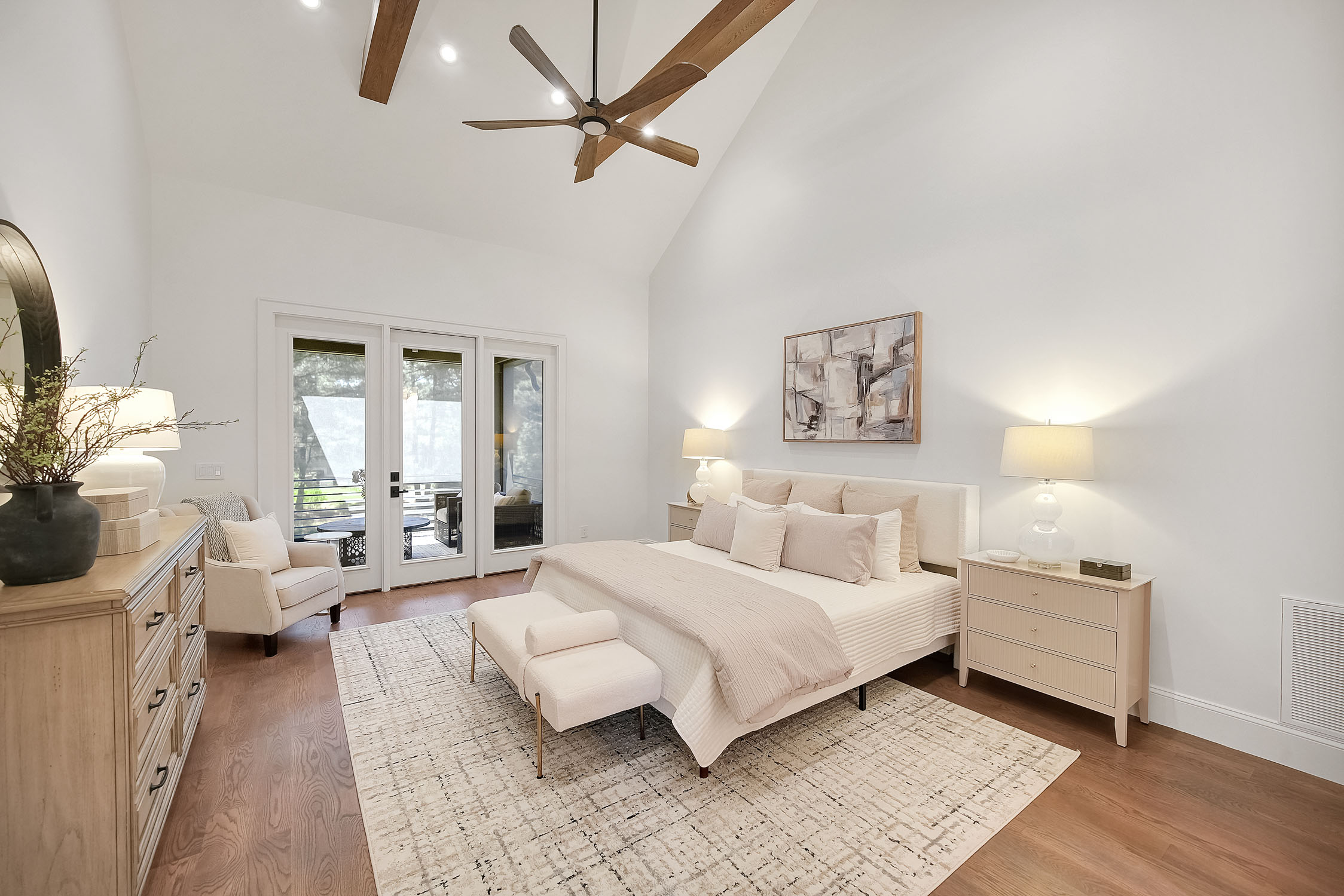 Modern bedroom with vaulted ceiling and balcony doors