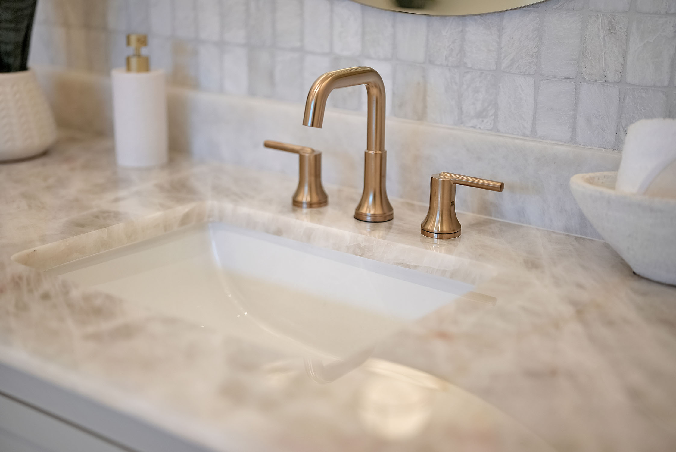 Brushed gold bathroom faucet on marble countertop