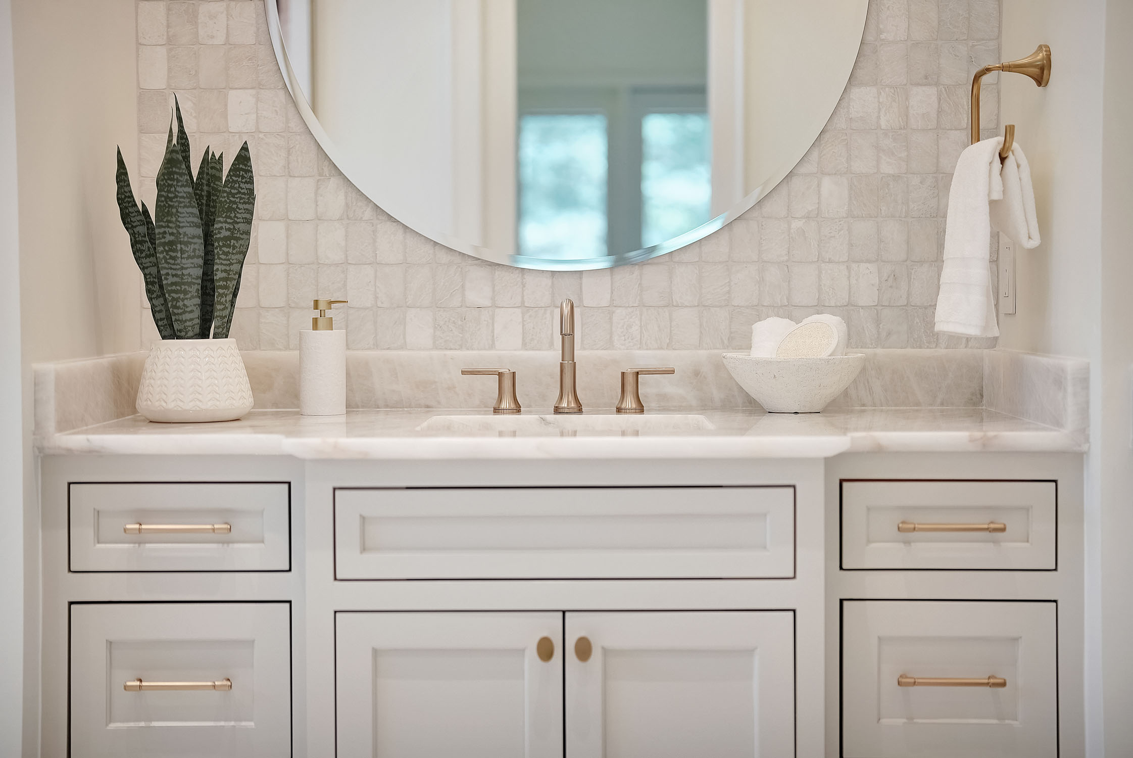 Modern bathroom vanity with marble countertop and brass fixtures