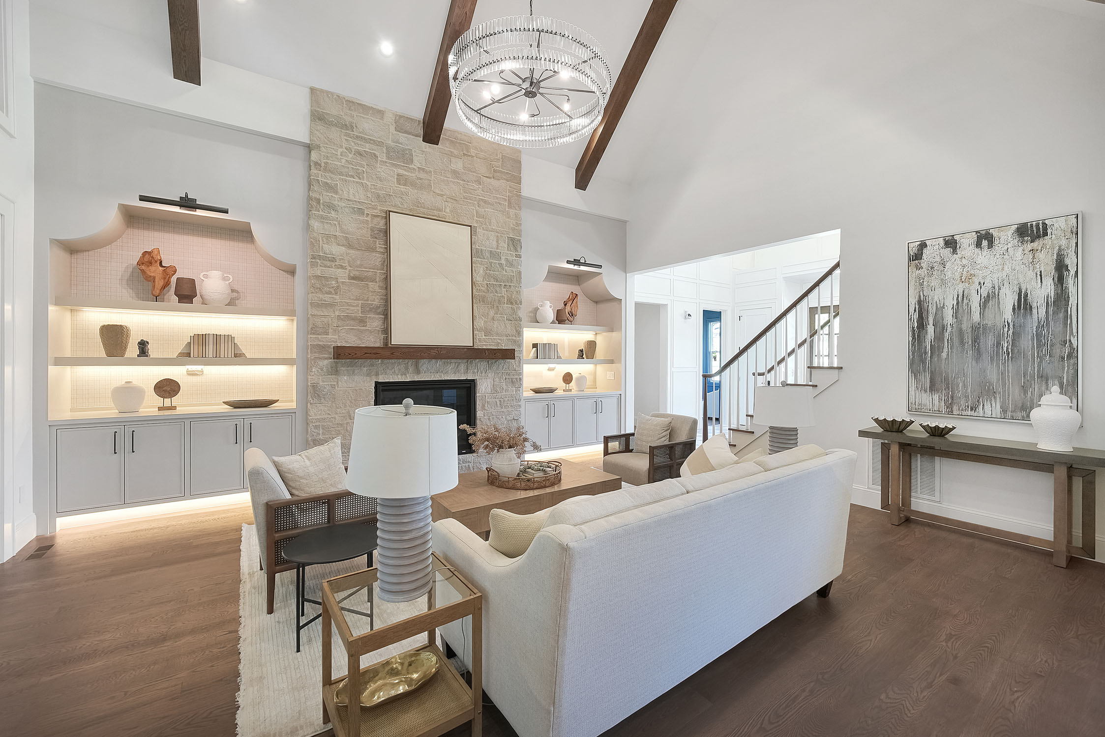 Modern living room with stone fireplace and chandelier