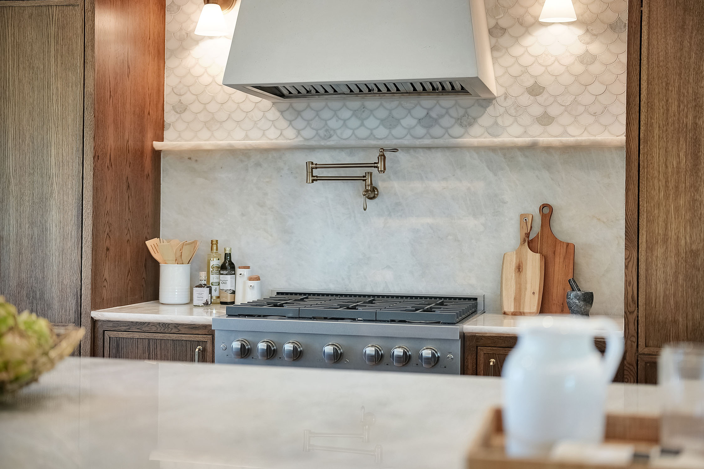 Modern kitchen stove with marble backsplash and wood cabinets