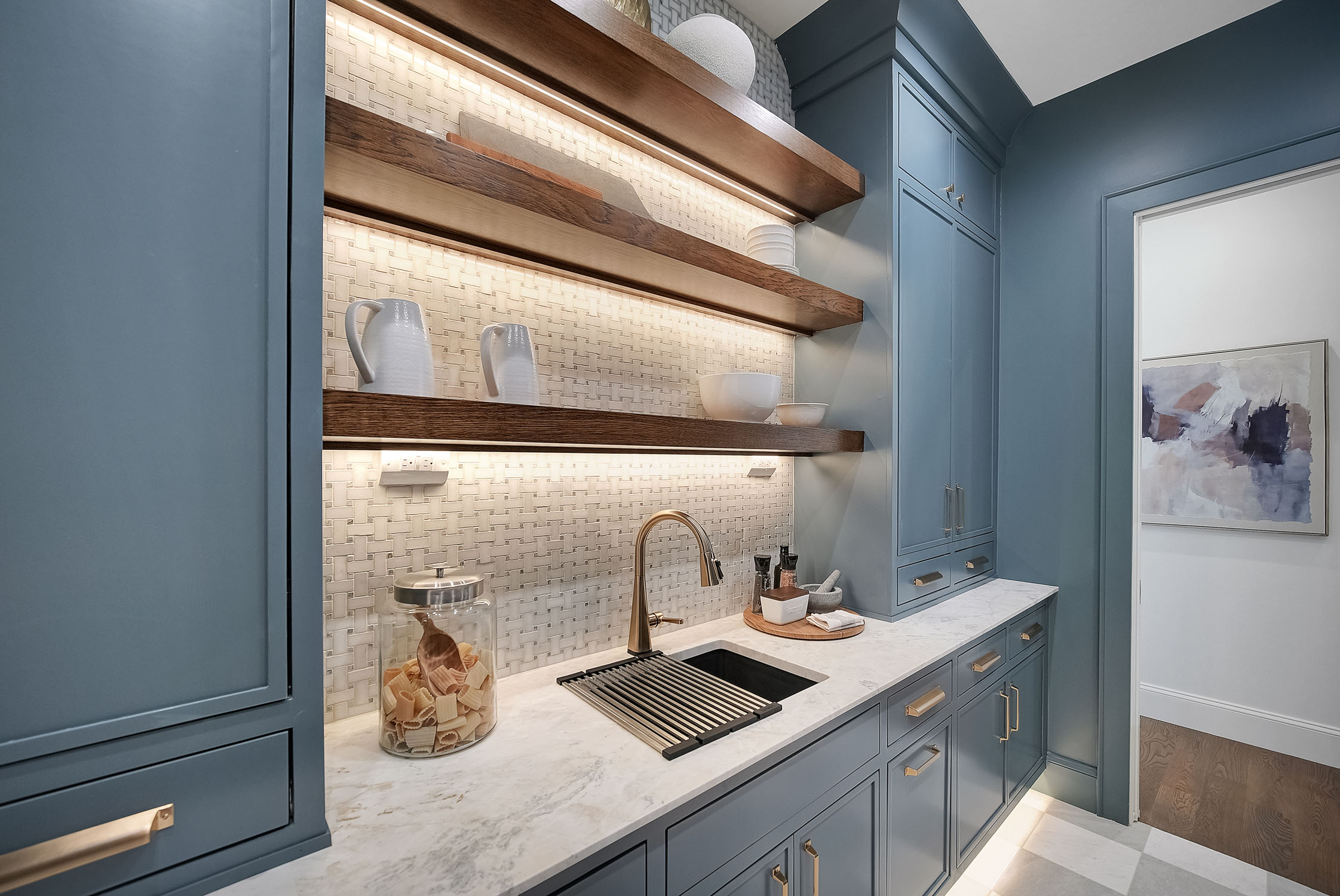 Modern blue kitchen with floating wood shelves