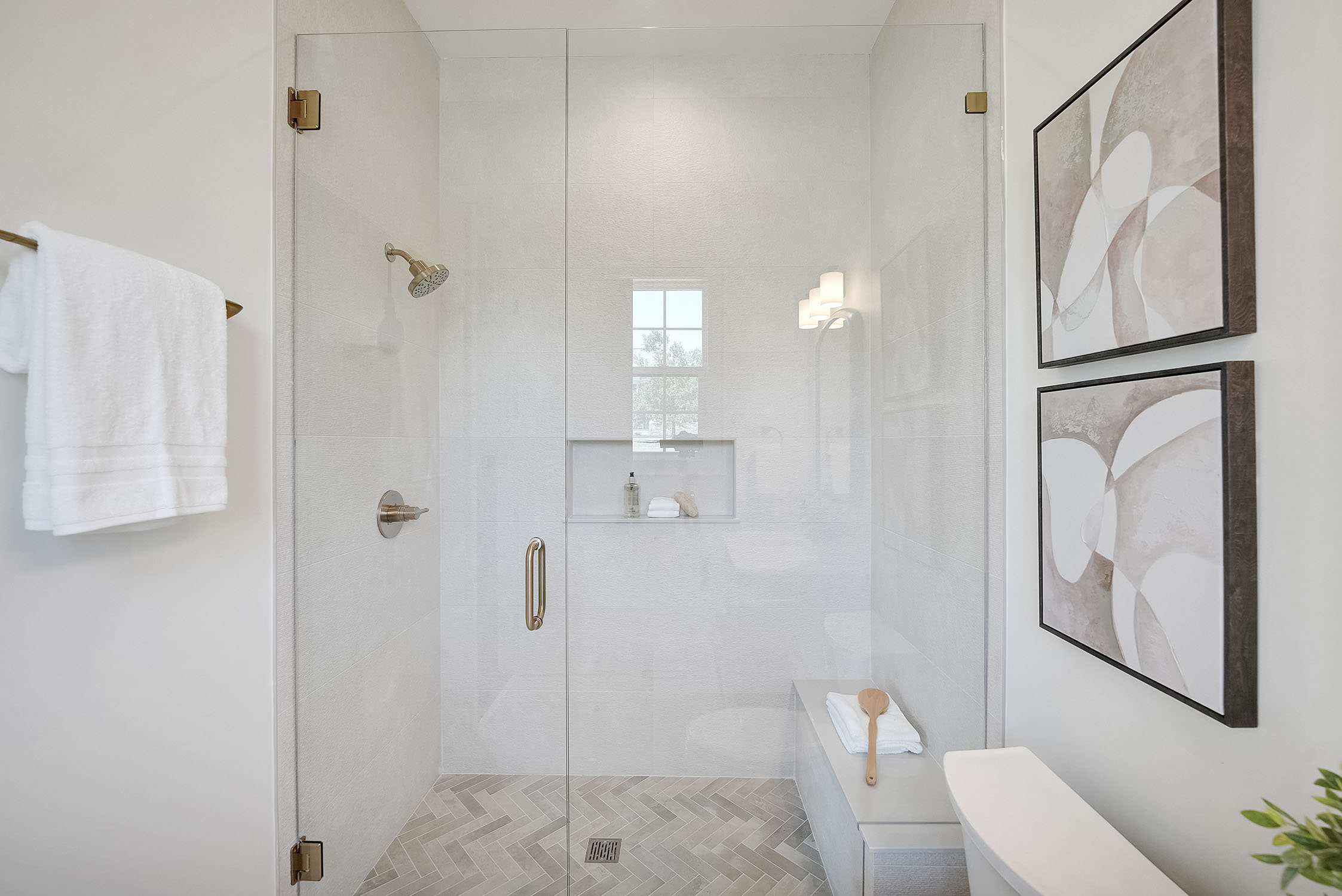 Modern glass-enclosed shower with brass fixtures