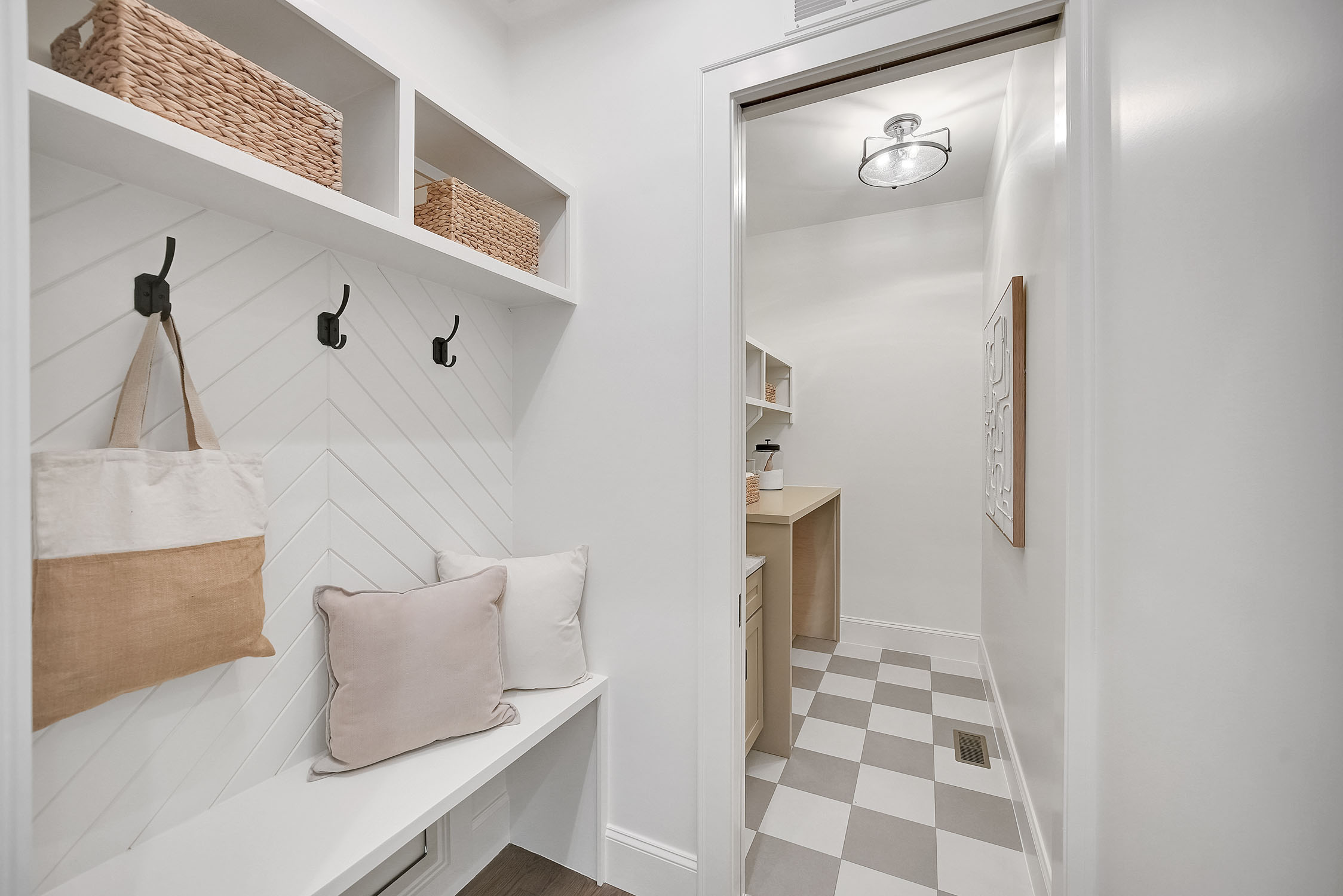 Bright mudroom with bench and checkered tile floor