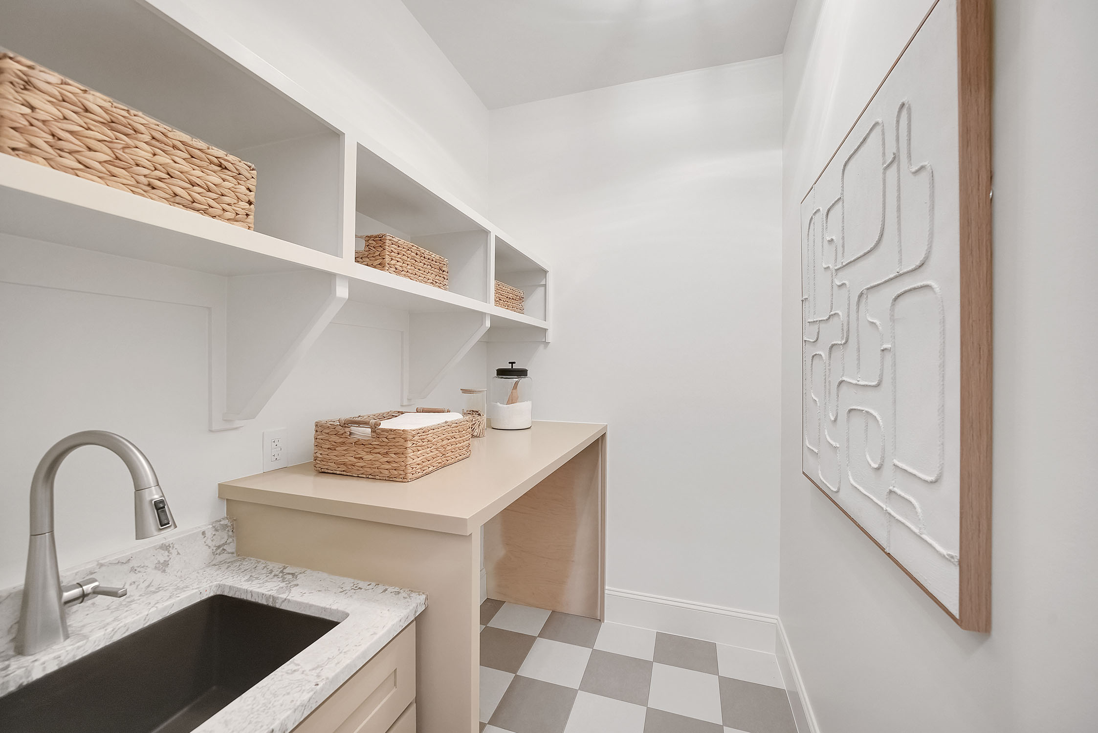 Bright laundry room with sink and woven baskets