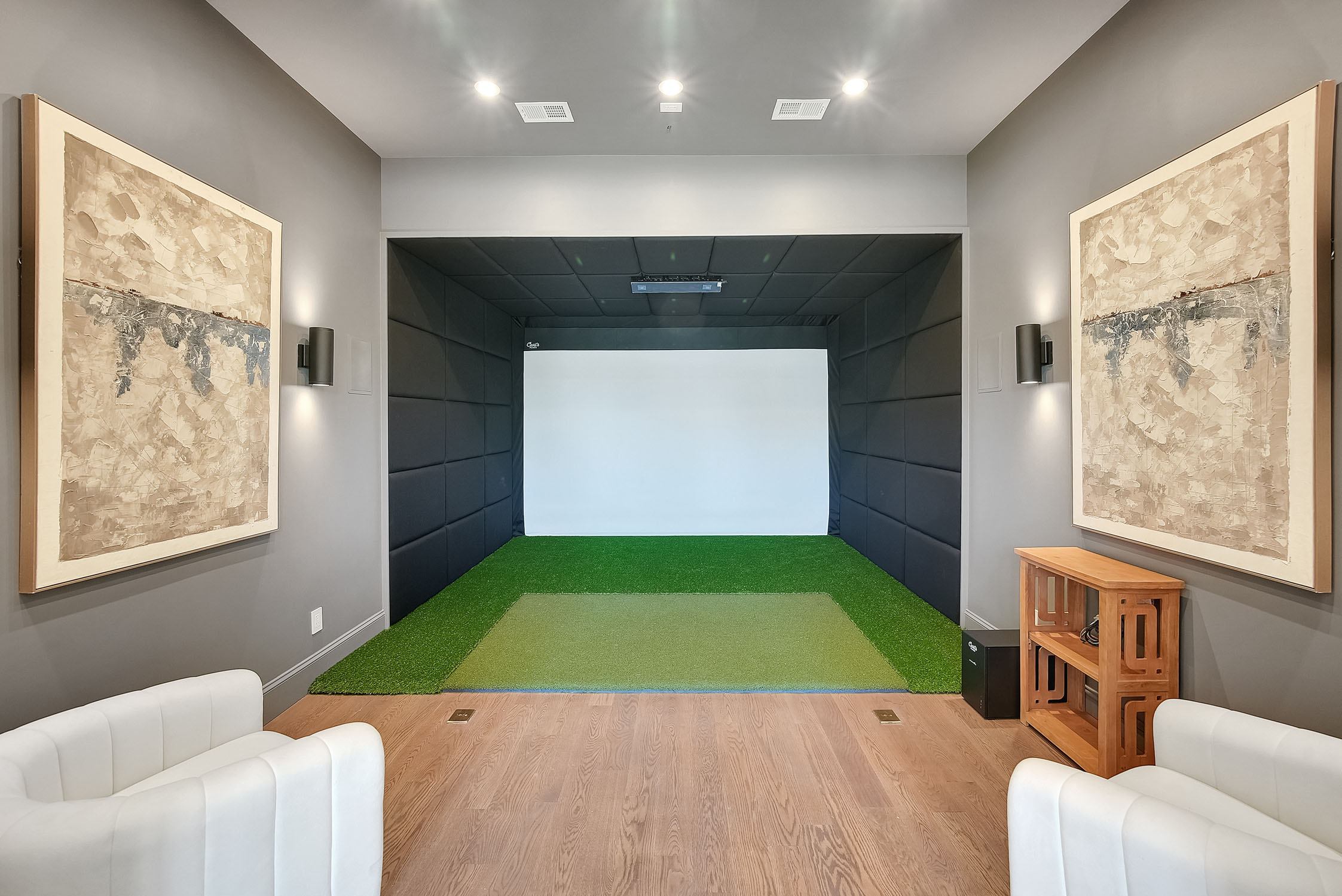 Modern indoor golf simulator room with projection screen