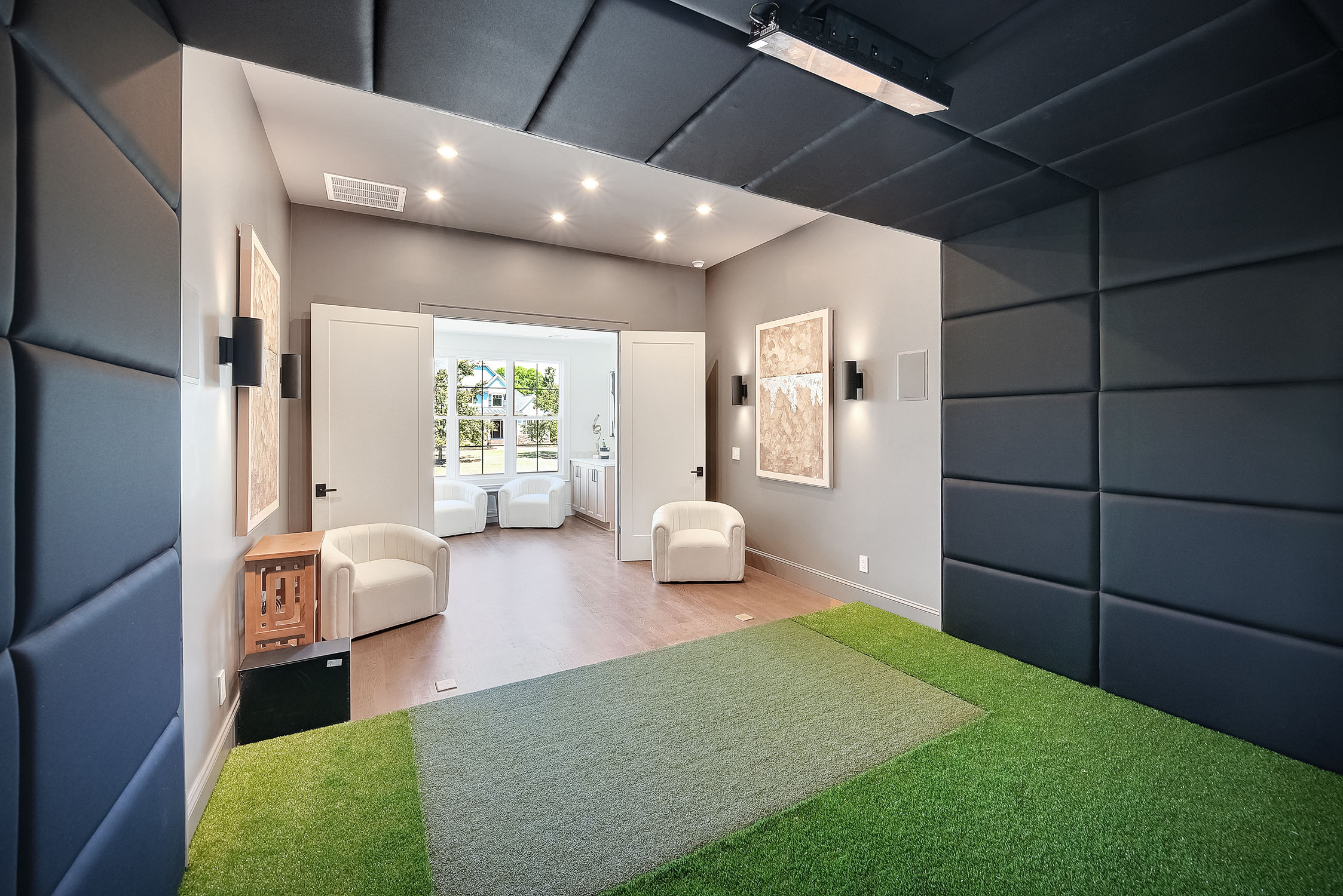 Modern indoor golf simulator room with padded walls