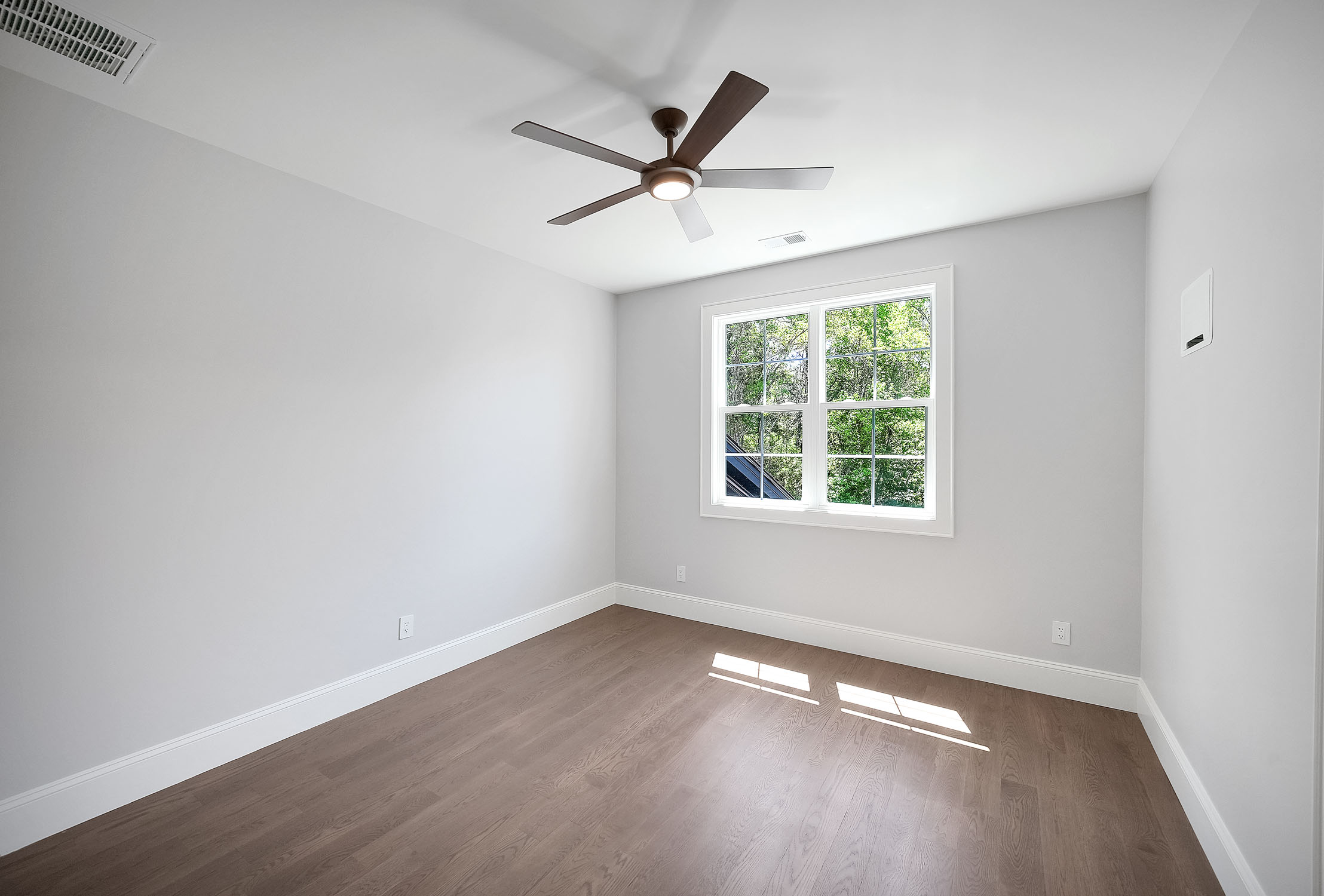 Empty modern room with ceiling fan and window