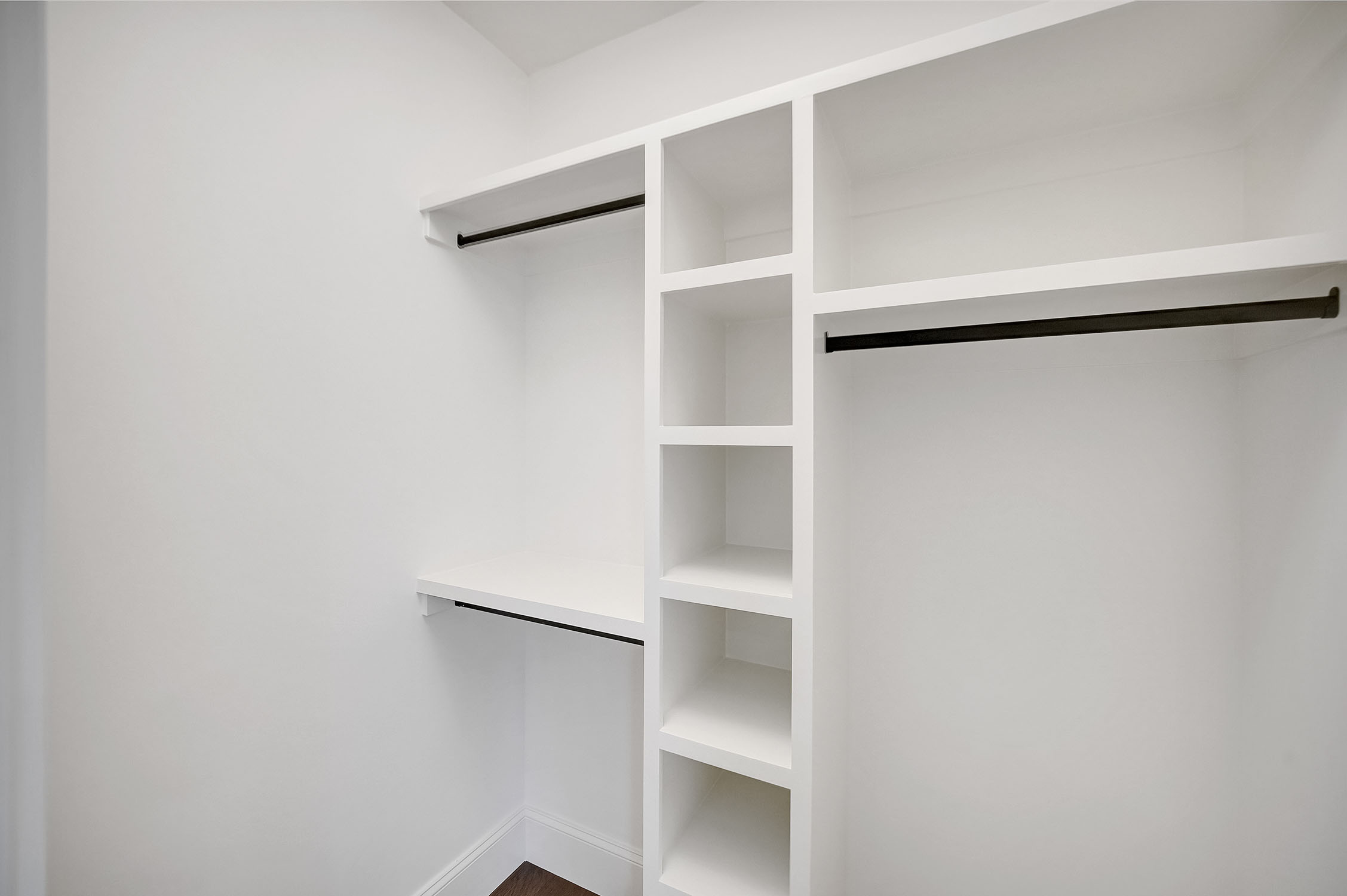 Modern white walk-in closet with built-in shelves