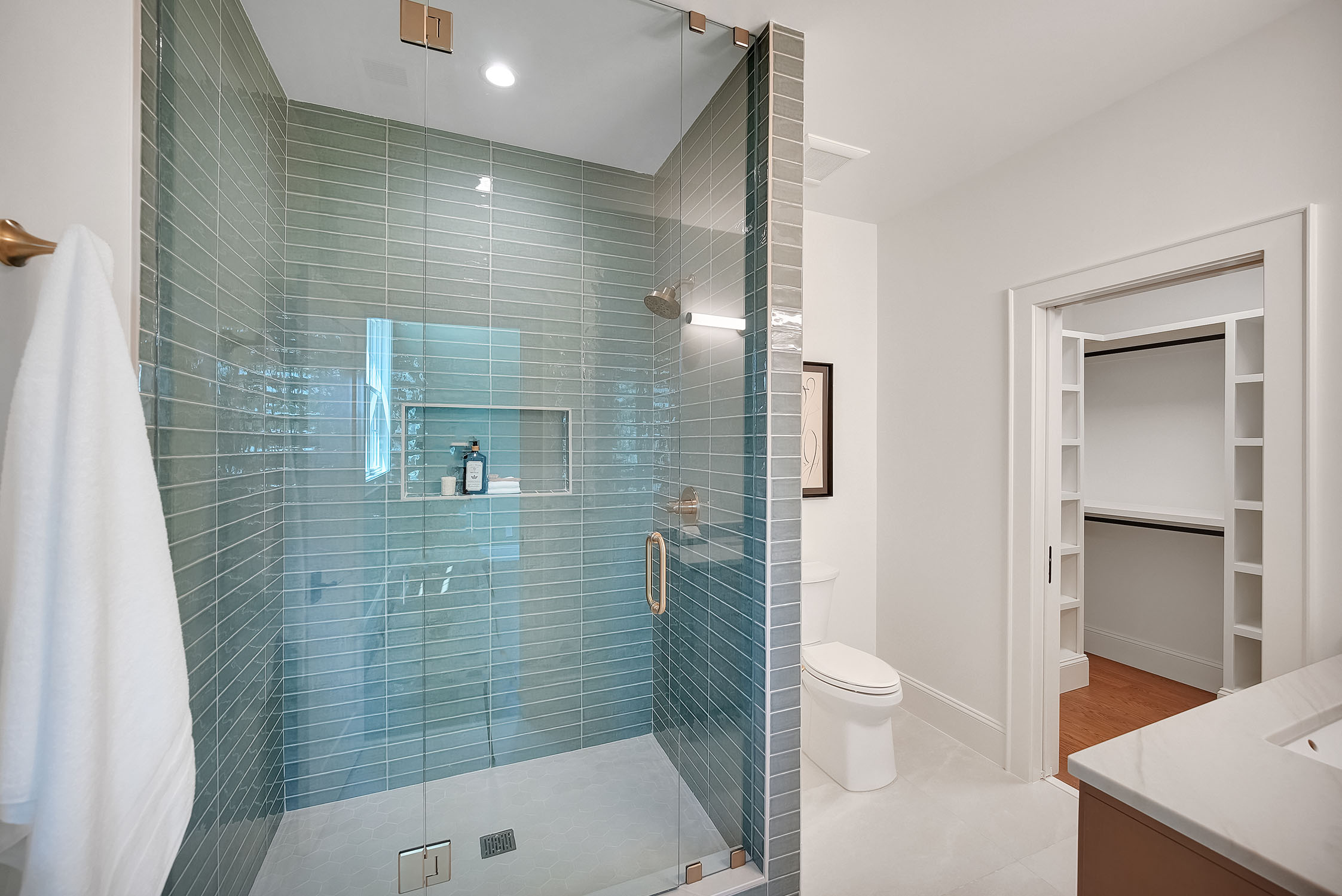 Modern bathroom with glass shower and teal tiles