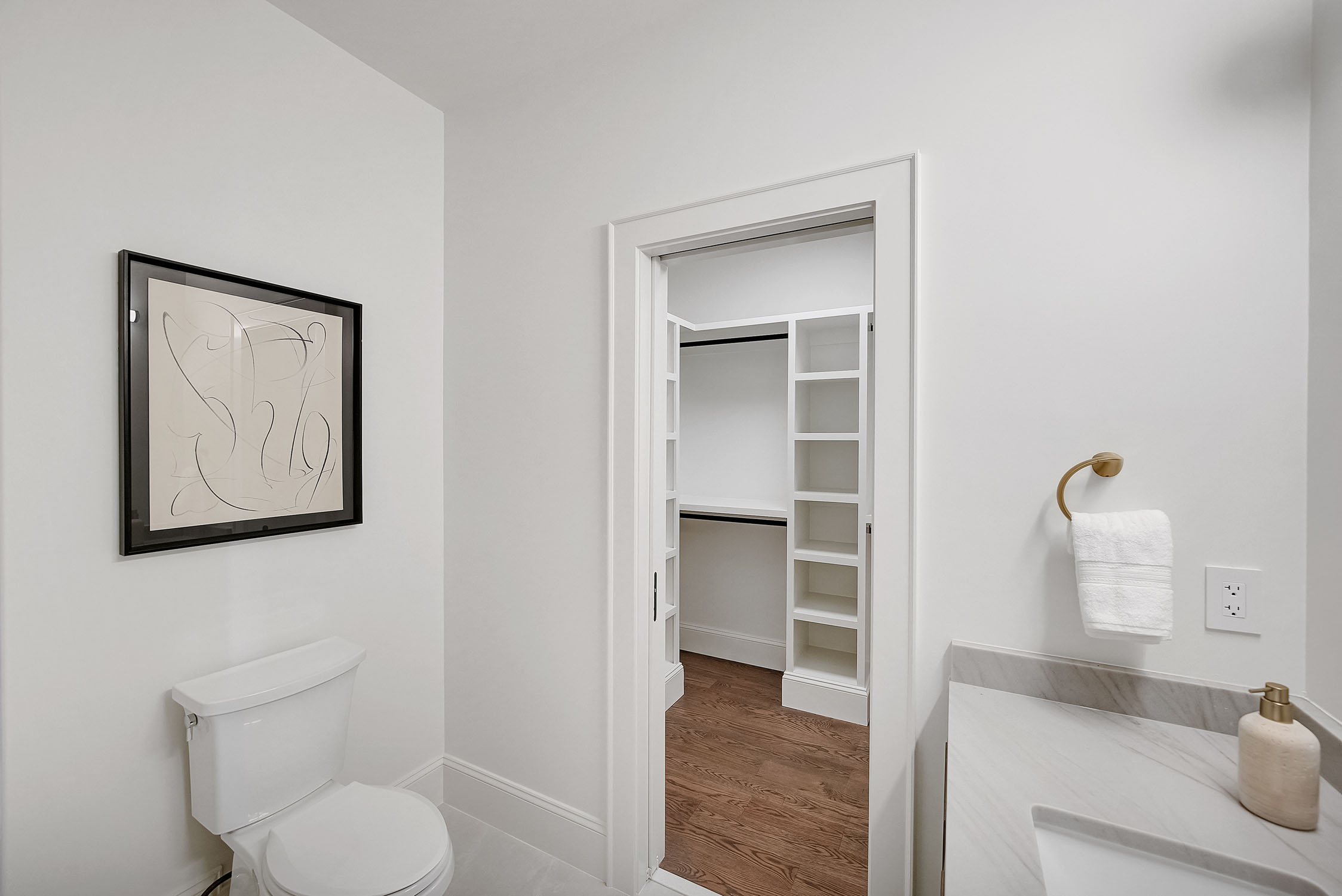Modern white bathroom with closet doorway