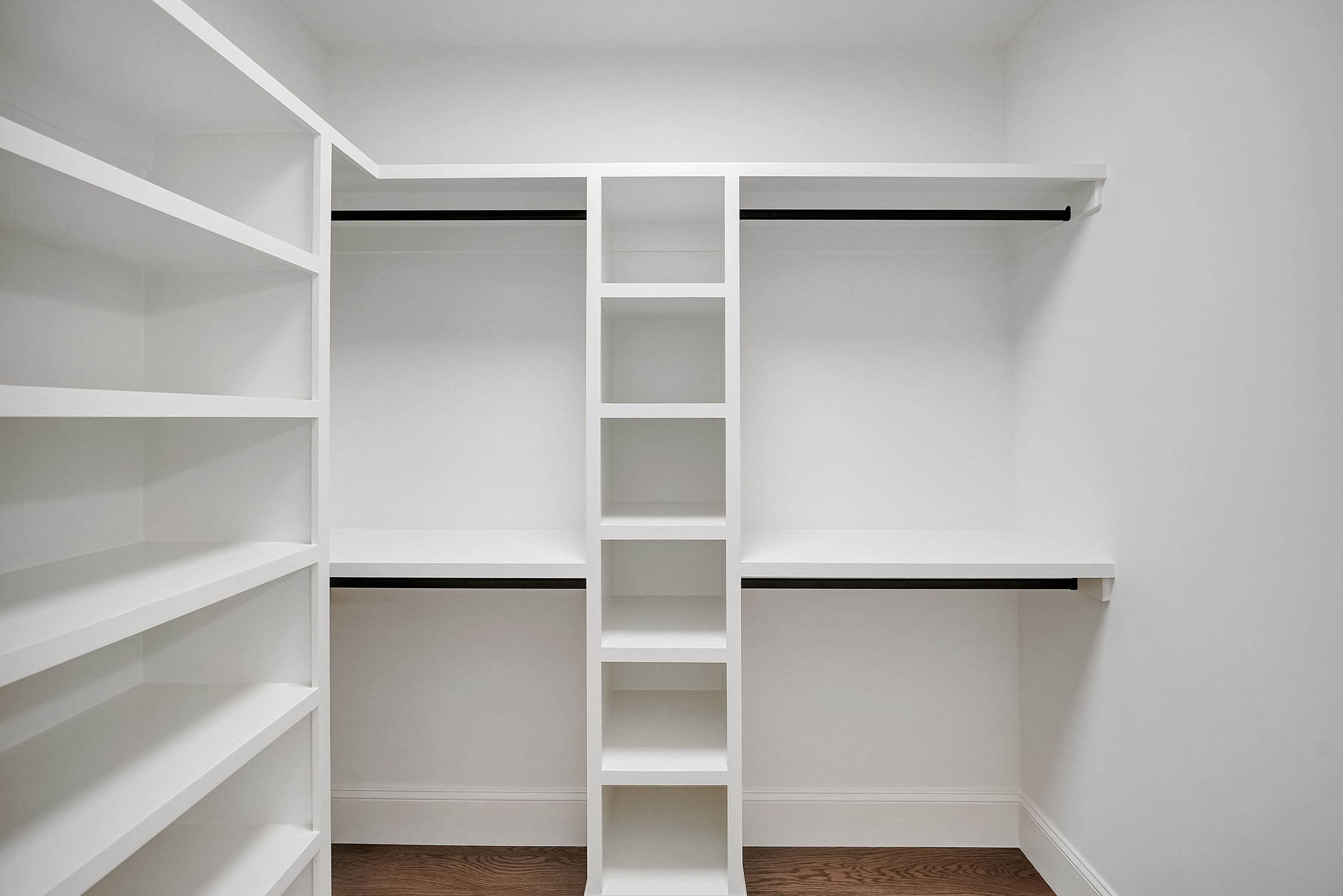 Empty white walk-in closet with built-in shelves