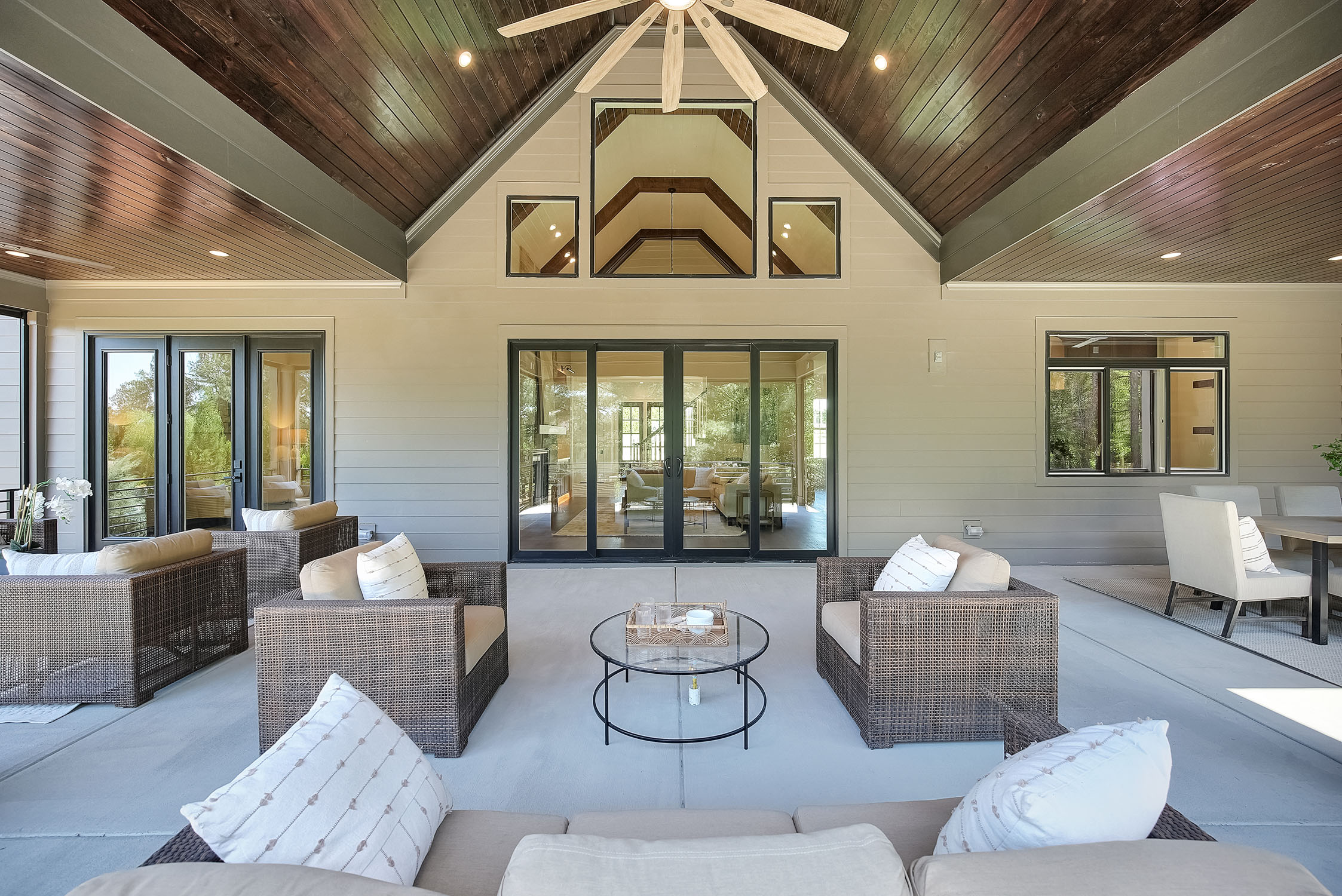 Covered patio with wicker seating and vaulted ceiling