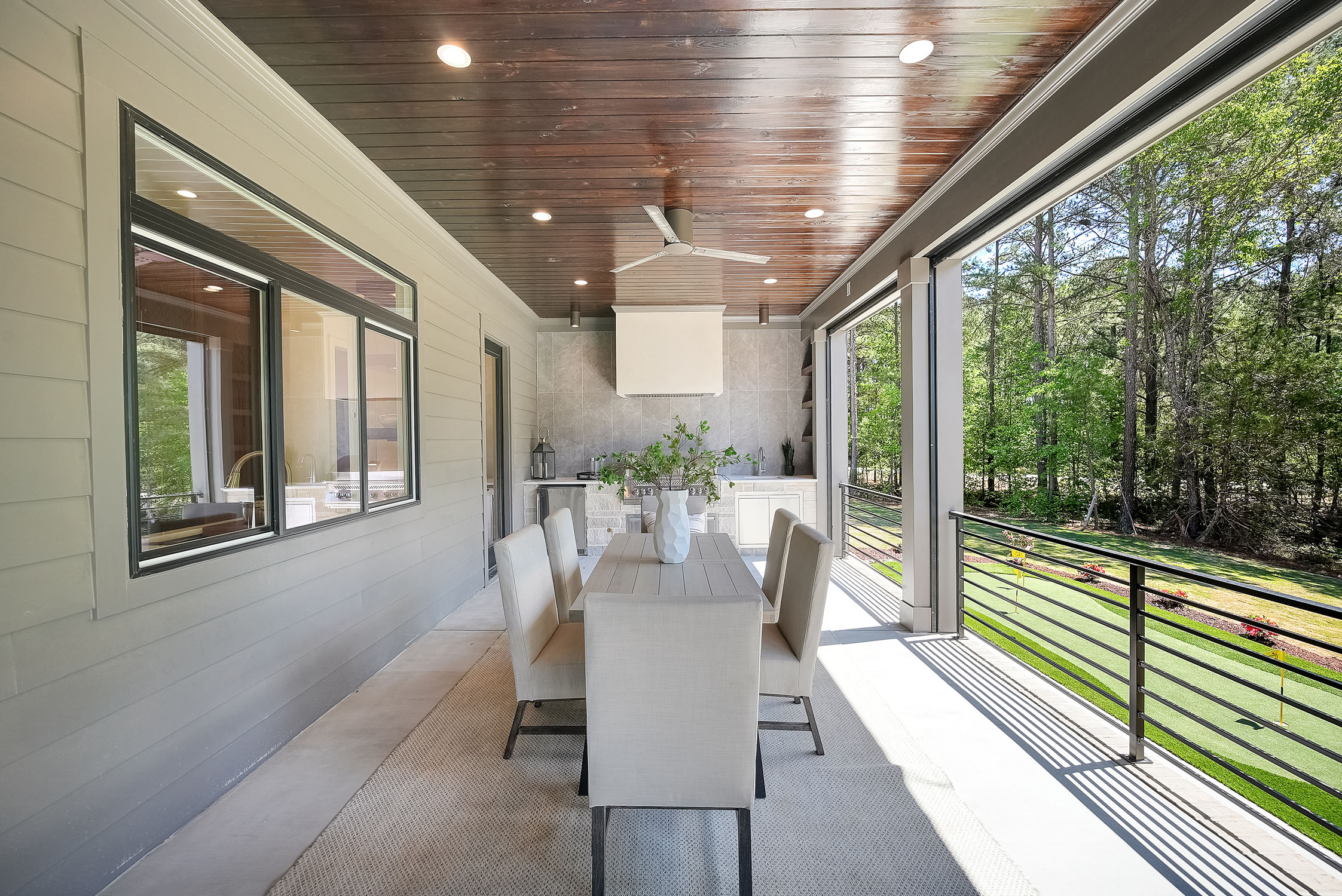 Covered patio with dining table and outdoor kitchen