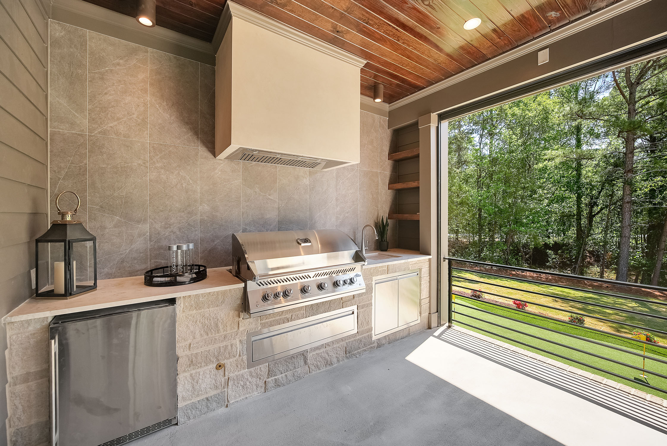 Modern outdoor kitchen with grill and forest view