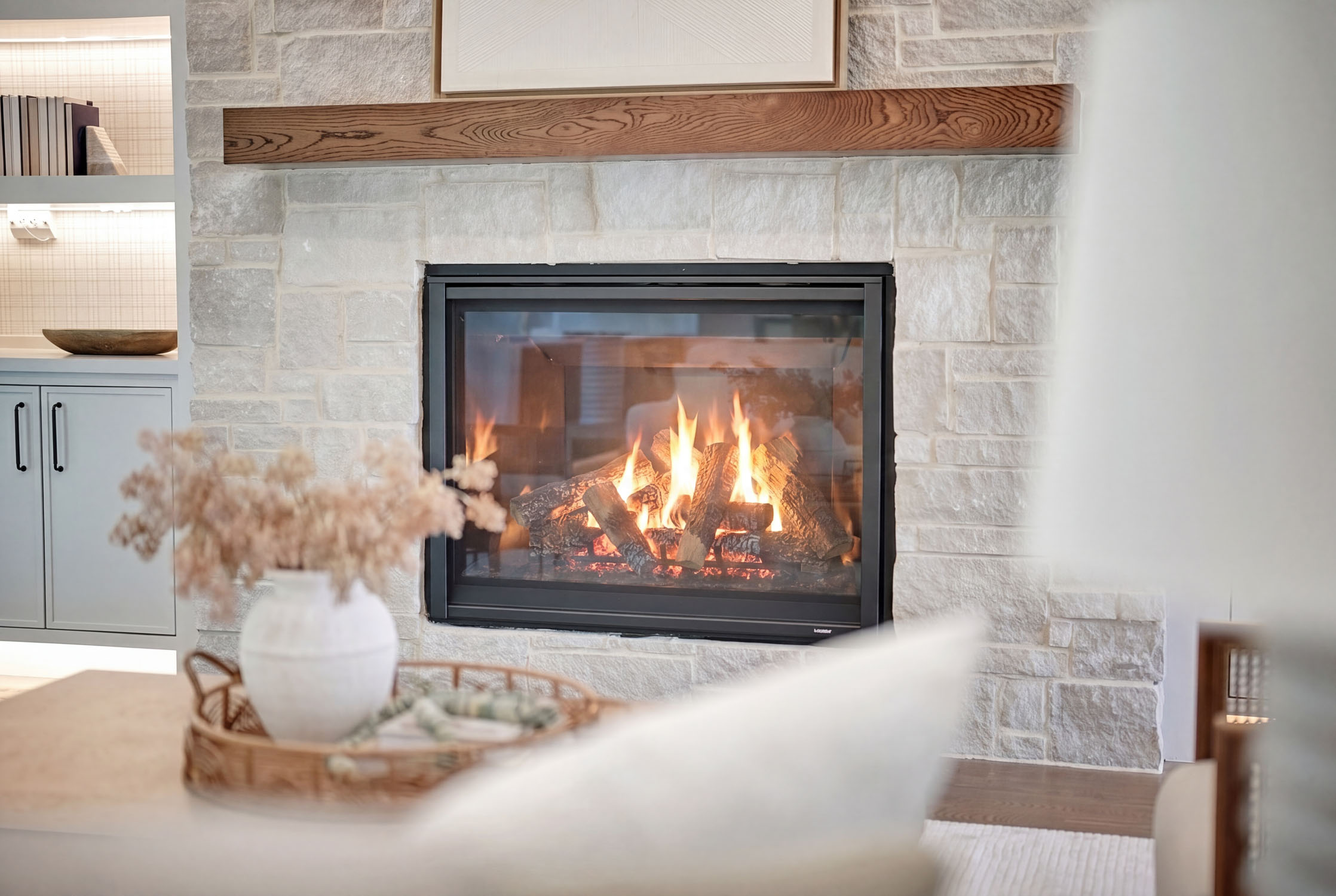 Modern stone fireplace with burning logs