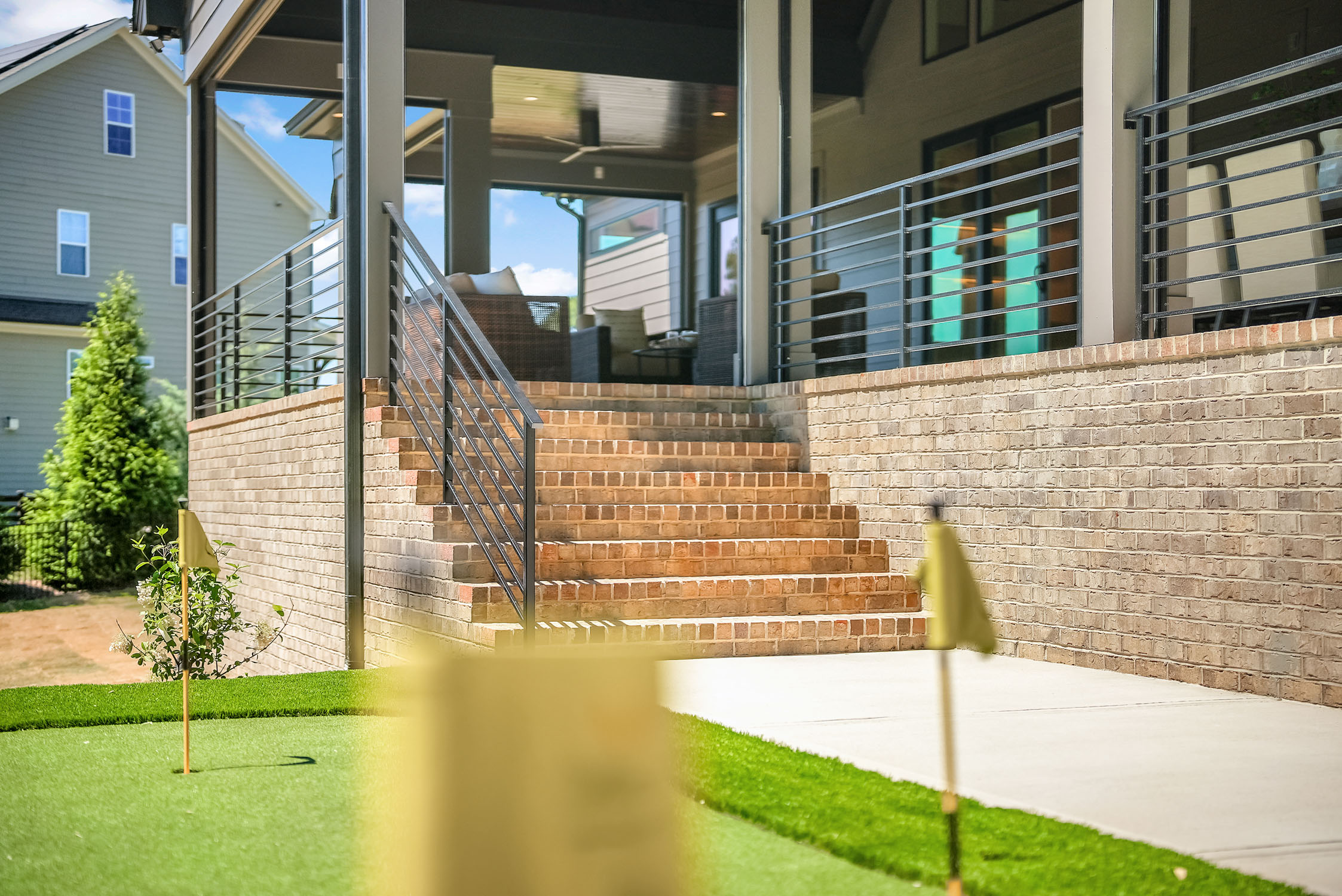 Brick steps leading to covered patio and putting green