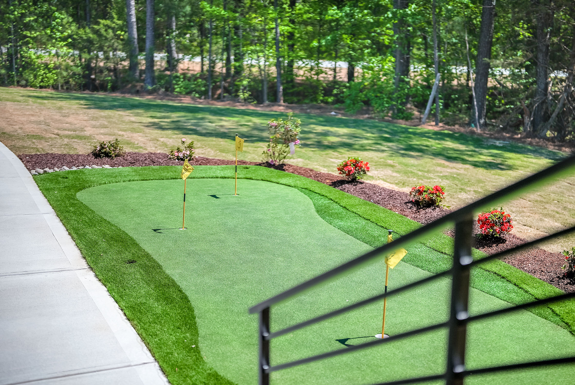 Backyard putting green with flags and landscaping