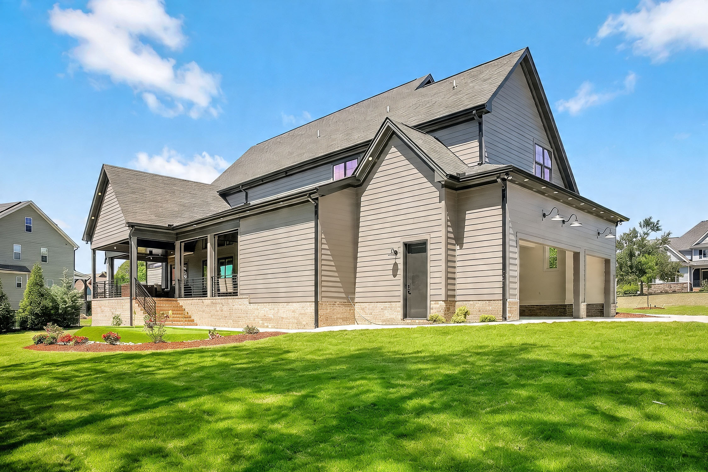 Modern gray suburban home with large green lawn