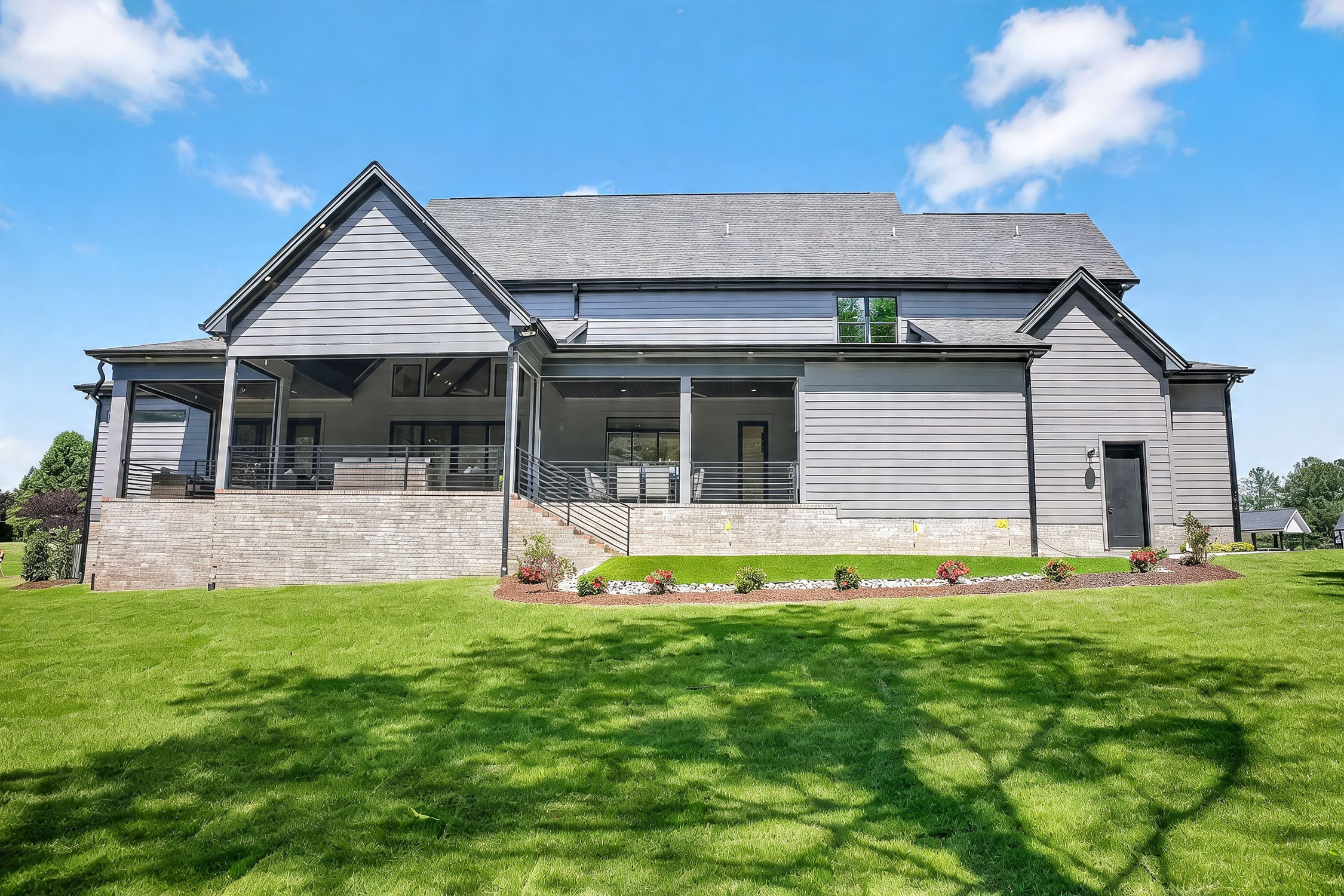 Modern gray house with covered patio and lawn