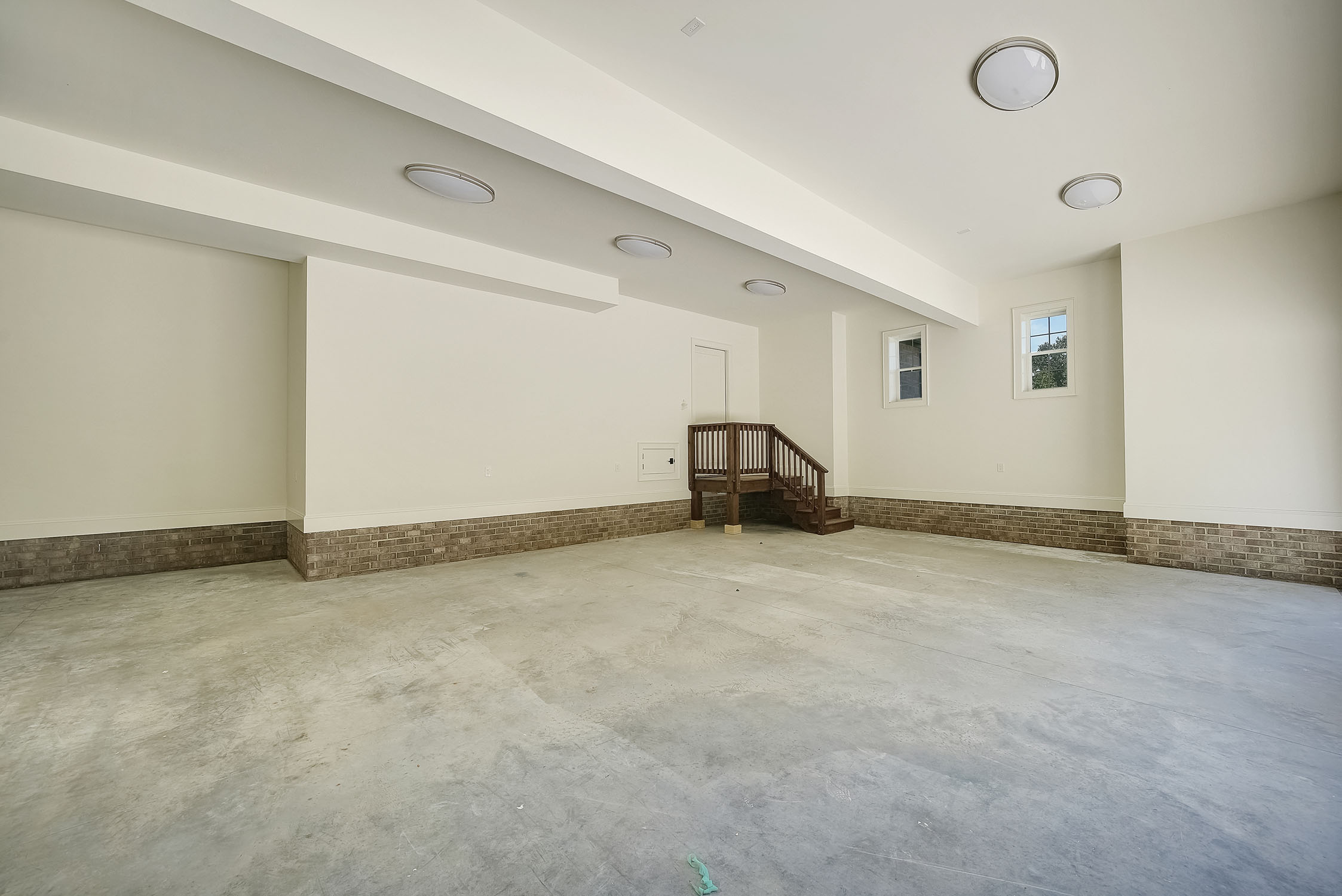 Spacious unfinished basement with staircase and windows