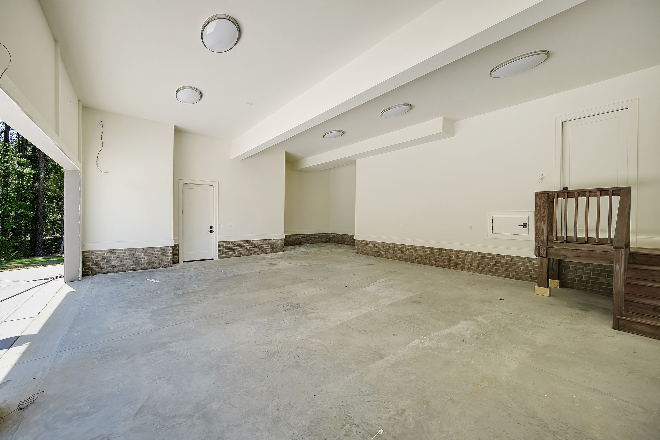 Spacious empty garage with concrete floor and ceiling lights