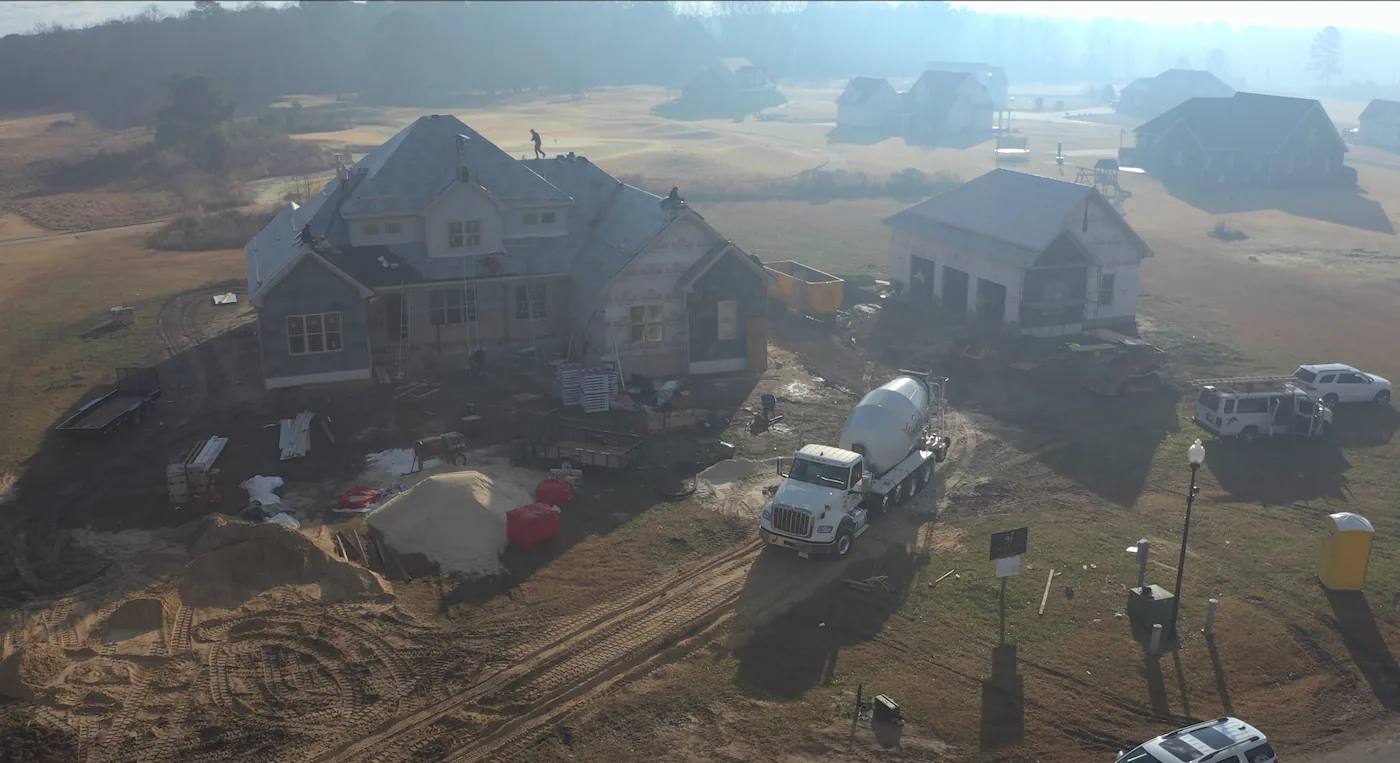 Construction site with cement truck and workers.