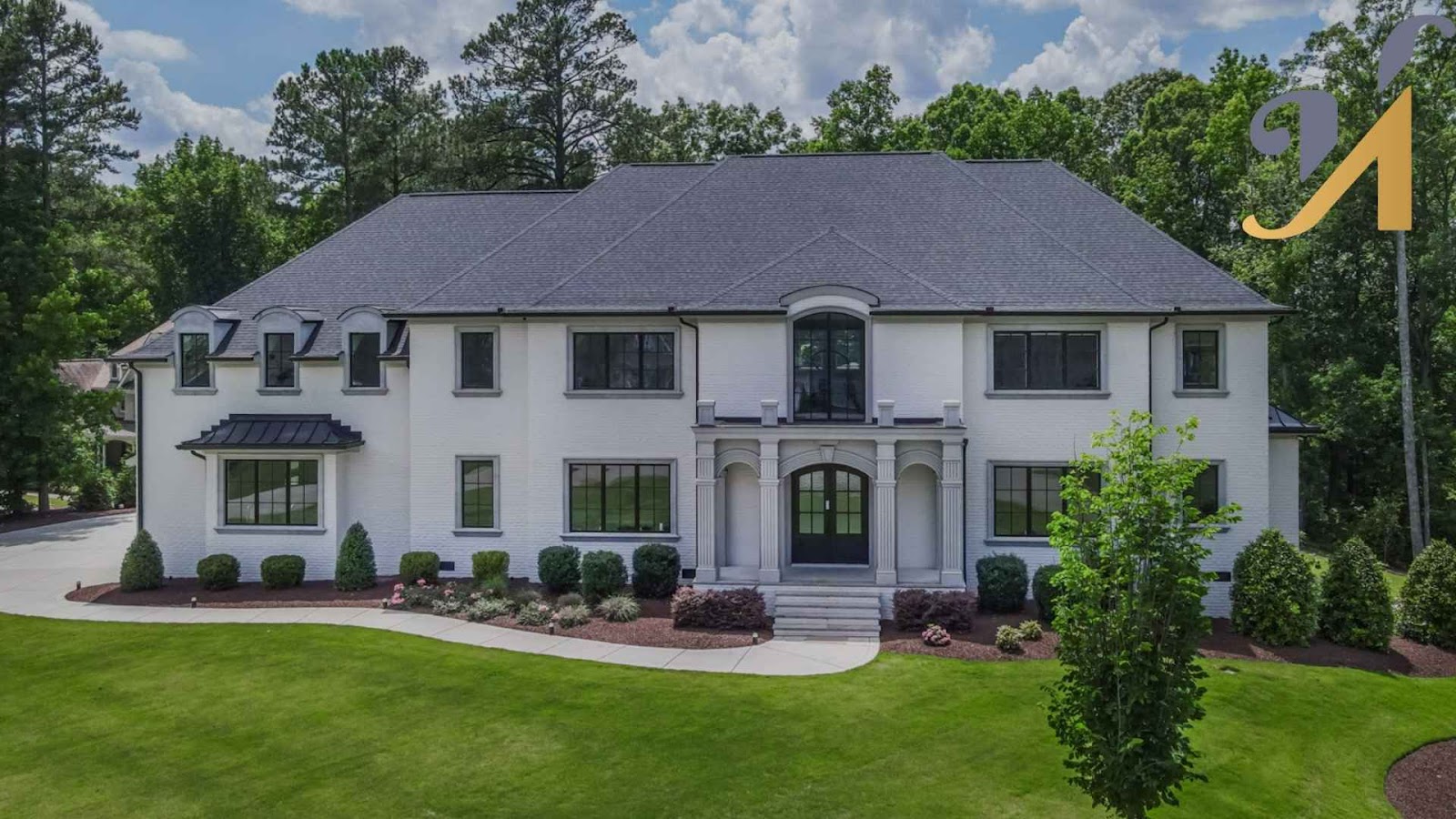 Large white house with green lawn and trees.