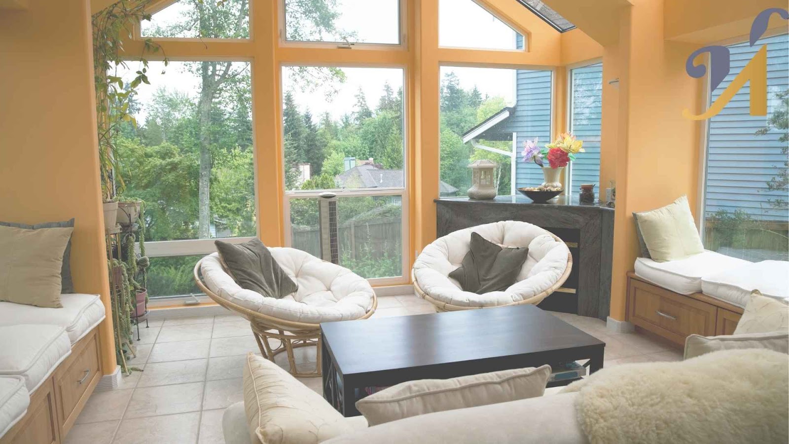 Bright sunroom with comfortable seating and large windows.