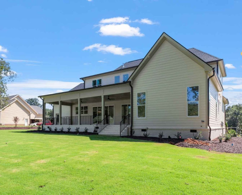 A custom-built home with a wide, open backyard and wraparound porch, designed to fit the land and natural light.
