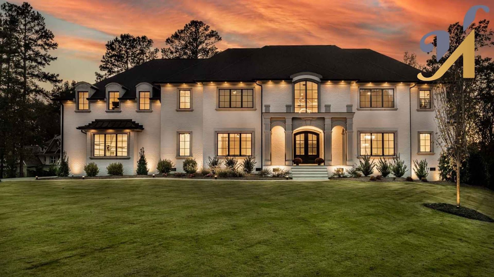 Luxury mansion at sunset with landscaped lawn.