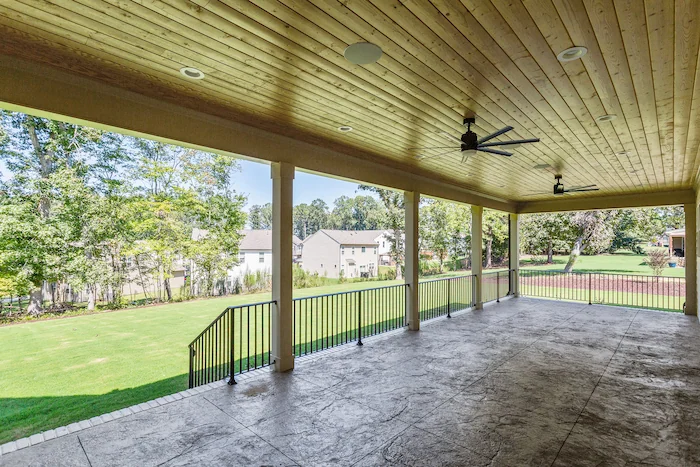 Spacious wooden deck overlooking green backyard