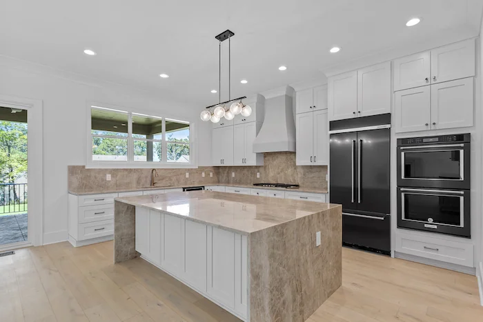 Modern kitchen with island and double ovens.