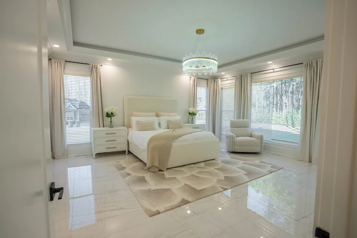 Luxurious bright bedroom with elegant decor and windows.