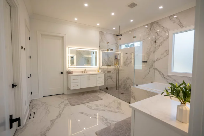Modern marble bathroom with glass shower and tub.