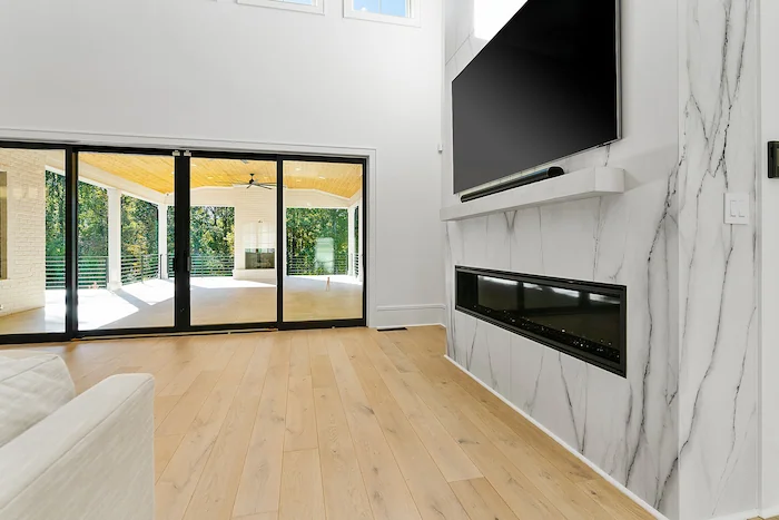 Modern living room with marble fireplace and TV.