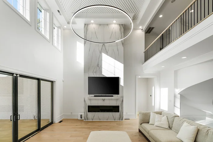 Modern living room with high ceilings and large windows.