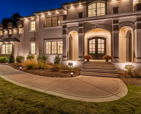 Elegant modern house exterior with nighttime lighting.